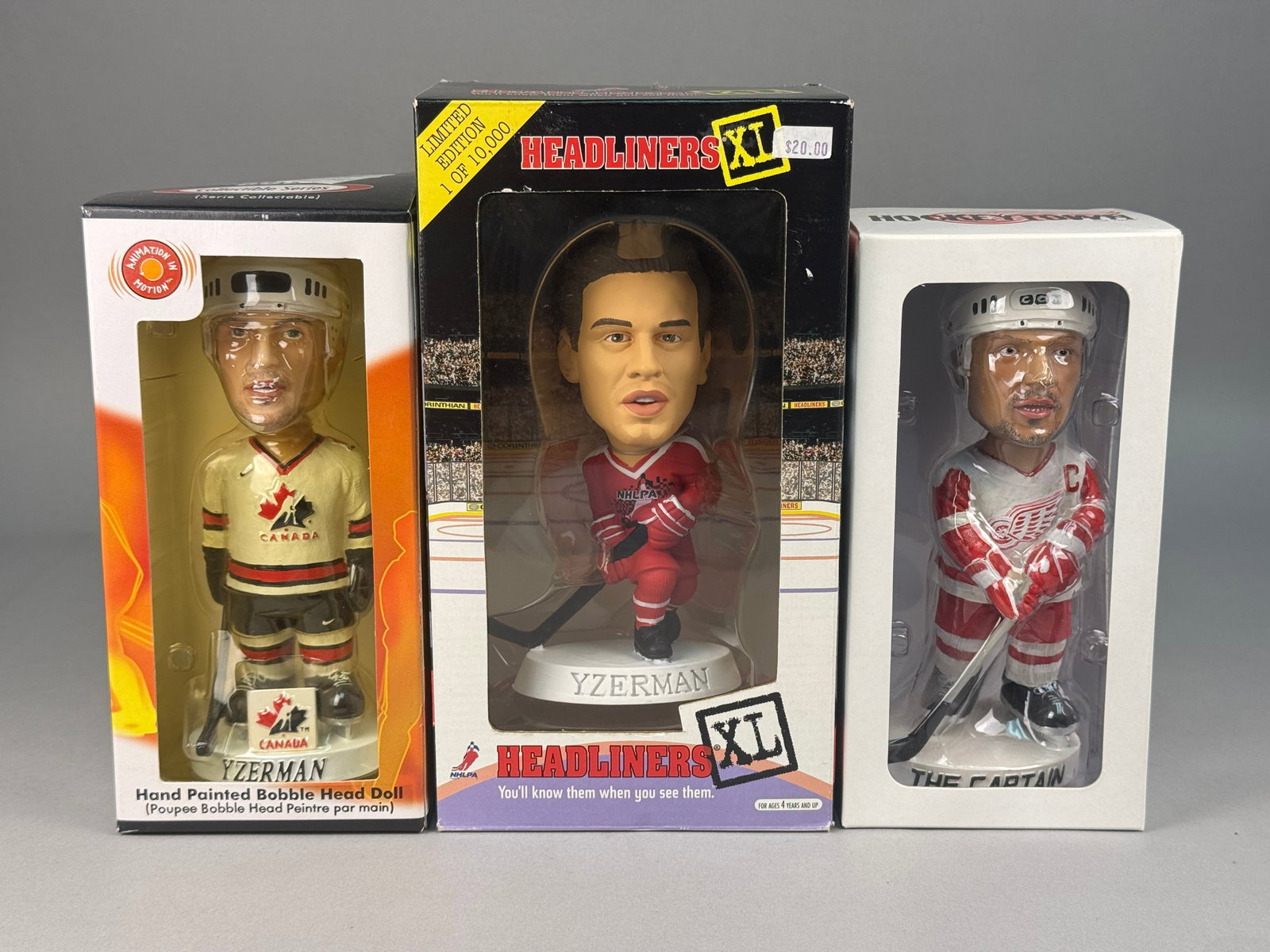 A Trio of Steve Yzerman Bobblehead Figurines: The collection includes one Corinthian Headliners XL 1998 Premier Collection figurine, depicting Yzerman in a red Detroit Red Wings jersey. This piece is a limited edition, numbered 1 of 10,000, with