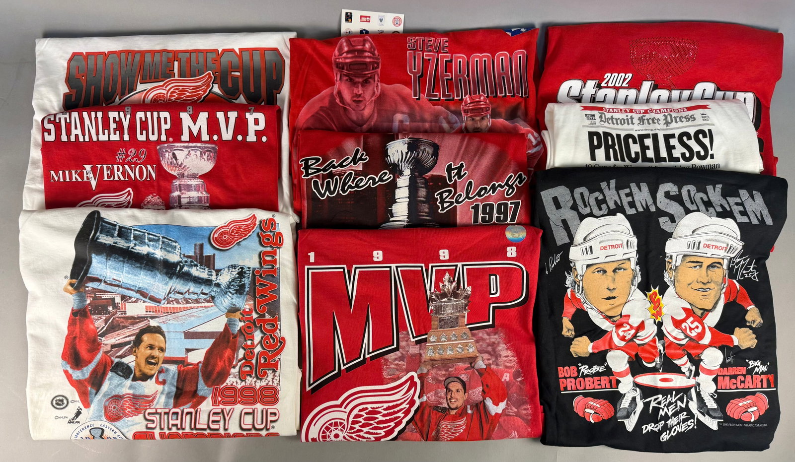 A Collection of Vintage Detroit Red Wings T-Shirts: Featured designs include a 1993 Rockem Sockem graphic featuring Bob Probert and Darren McCarty (copyright 1993 Kovacs / Magic Images), a 1997 Mike Vernon Stanley Cup MVP shirt, a 1998 Steve Yzerman