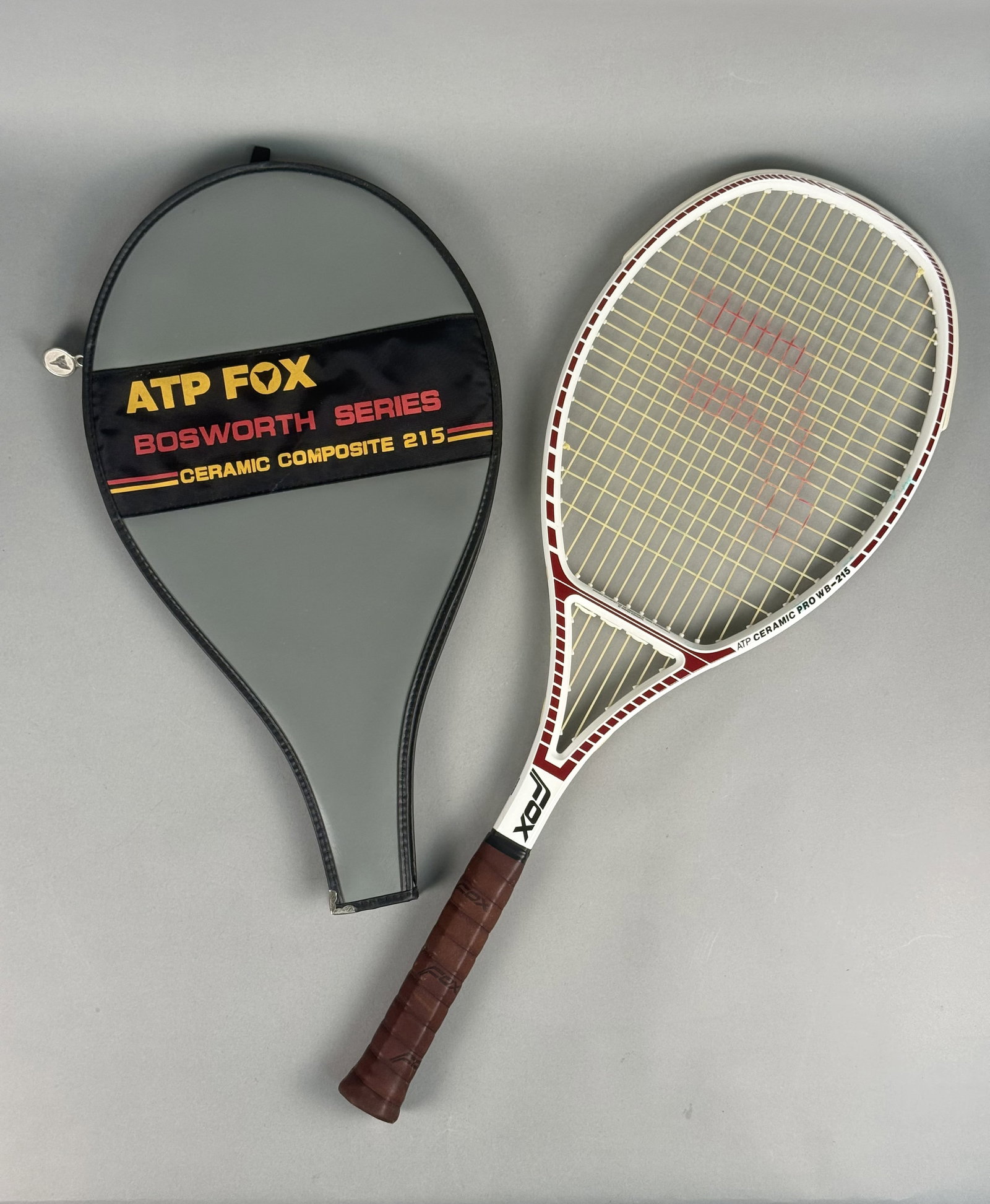 ATP Fox Bosworth Series Ceramic Pro WB-215 Tennis Racquet: This ATP Fox Bosworth Series tennis racquet is identified as the Ceramic Pro WB-215 model by markings on the frame. The racquet features a composite construction of ceramic, graphite, and fiberglass a