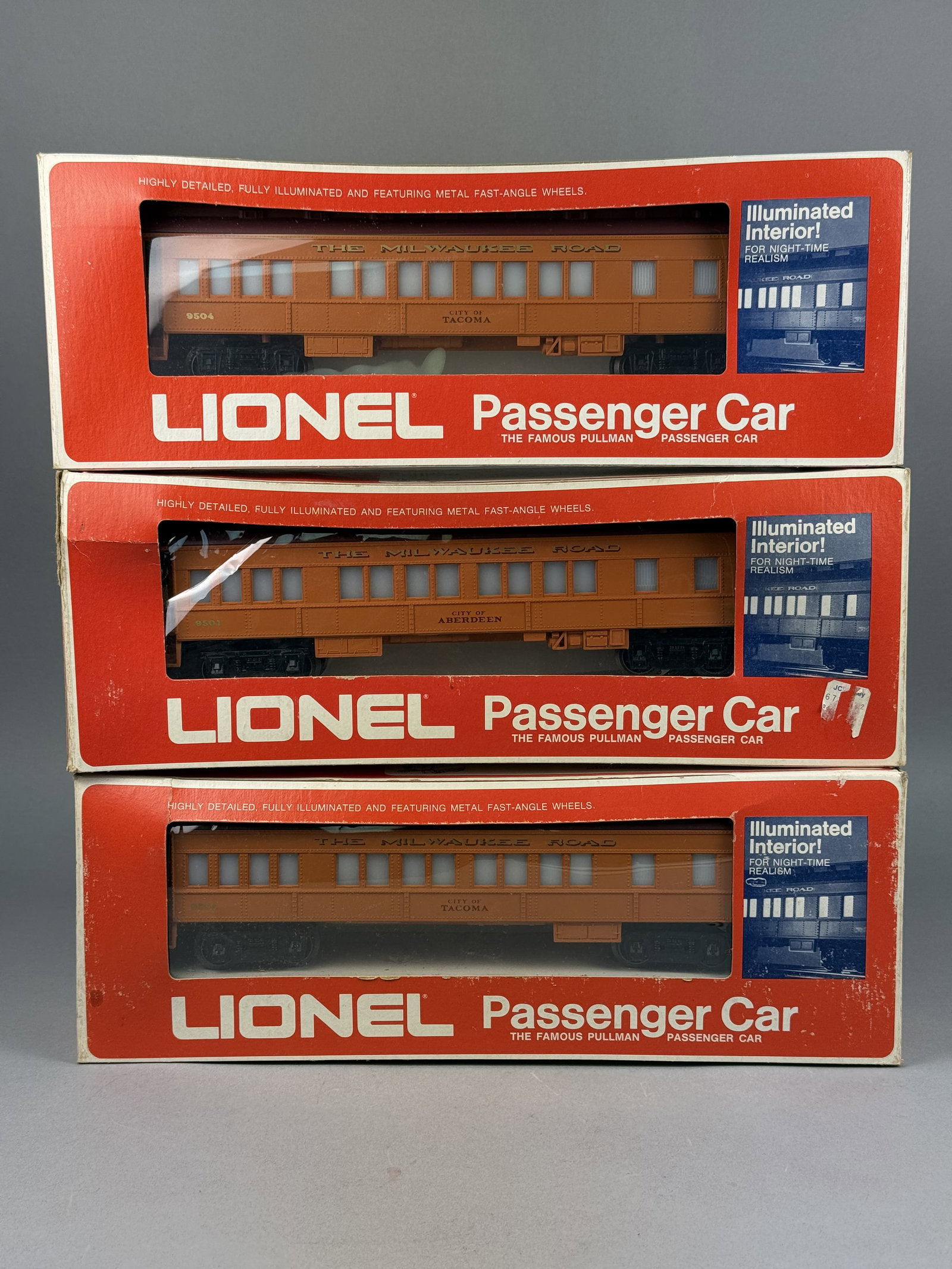 Three Lionel O Gauge Milwaukee Road Passenger Cars: This lot consists of three Lionel O gauge passenger cars decorated in the orange and maroon livery of The Milwaukee Road. These models date from the Fundimensions era when Lionel was a division of the