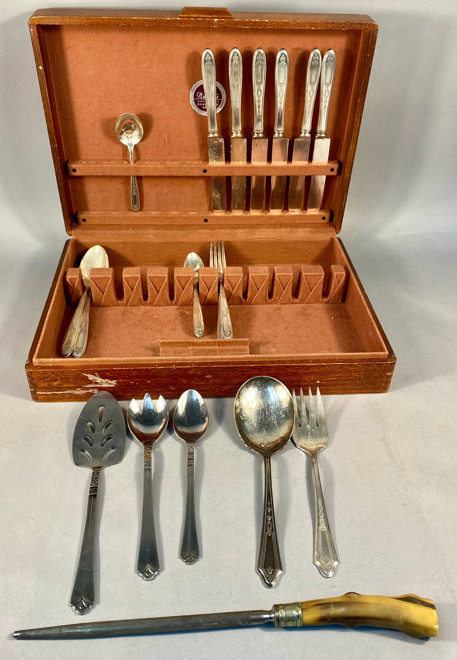Oneida Community & Tudor Silver Plate Flatware & Serving Pieces with Honing Steel and Chest: This is a gathered collection of silver-plated flatware and assorted serving pieces, primarily by Oneida, housed in a fitted wooden storage chest. The primary pattern for the place settings is Oneida