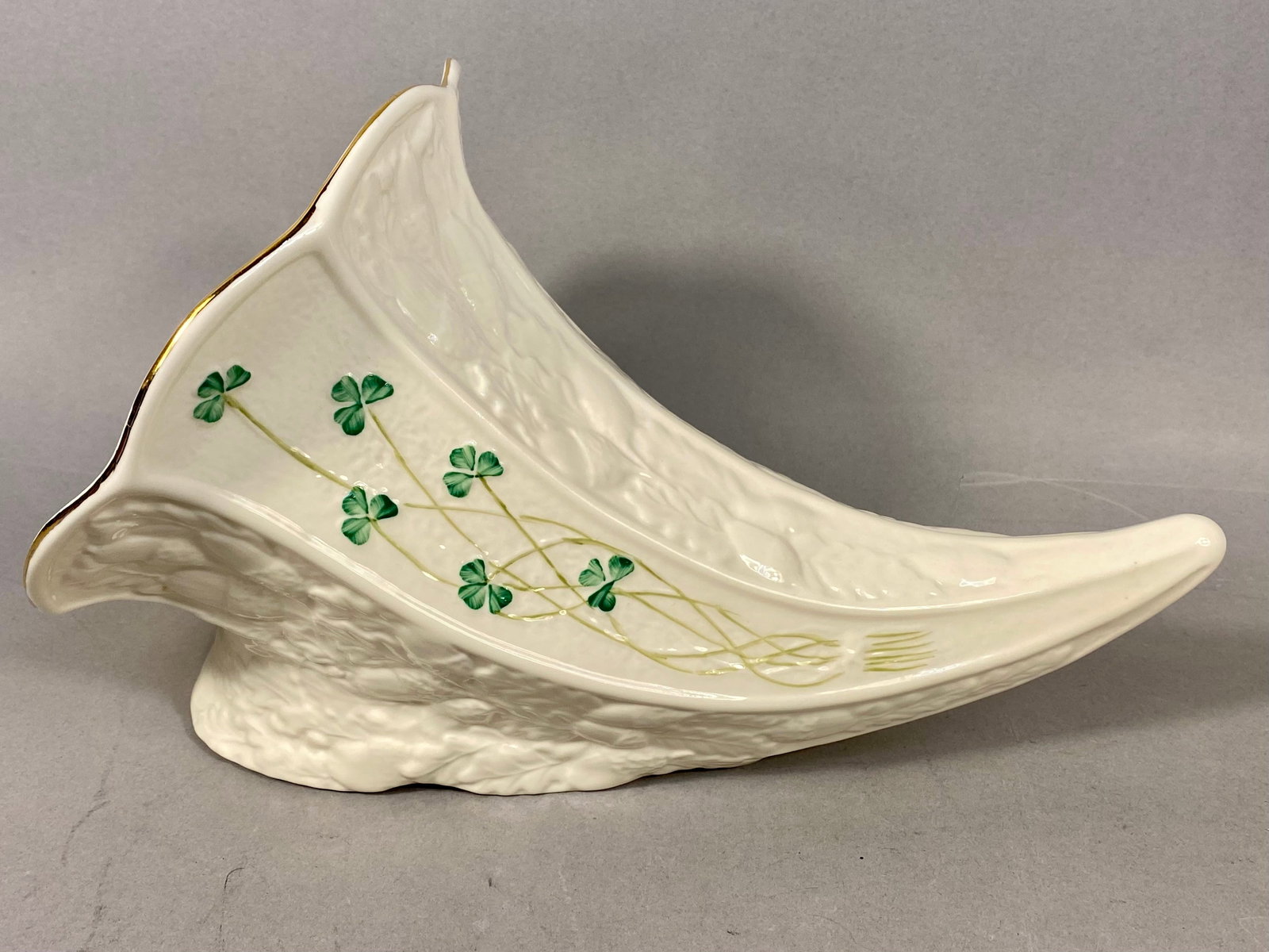 Belleek Ireland Shamrock Pattern Parian Porcelain Cornucopia Vase: A horn-shaped cornucopia vase produced by Belleek Pottery in County Fermanagh, Ireland. The piece is crafted from Parian porcelain and features the factory signature iridescent pearlescent glaze. The