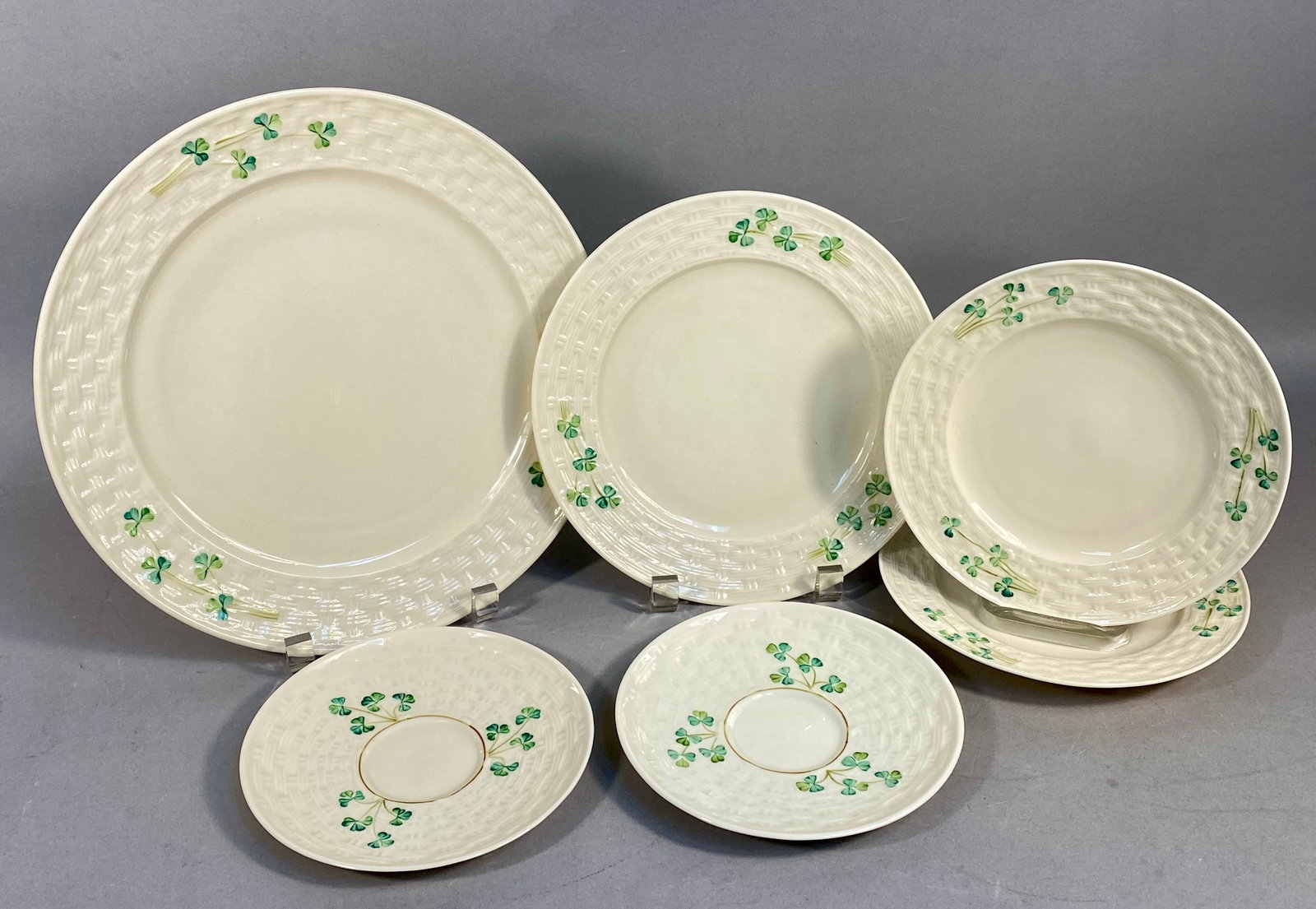 Six Belleek Classic Shamrock Pattern Parian Porcelain Tableware: This collection of six Belleek parian porcelain tableware is decorated in the Classic Shamrock pattern. Each piece features a cream colored body with a molded basketweave texture and hand painted