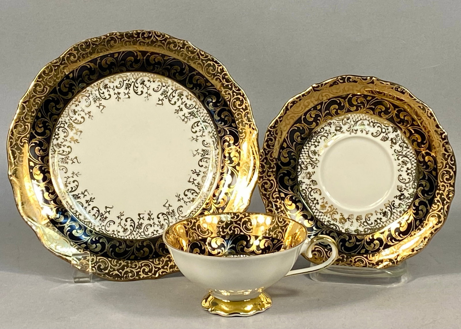 Eberthal Bavaria Porcelain Tea Service in Cobalt Blue & Gold: A trio of porcelain items manufactured by Eberthal in Bavaria, West Germany, consisting of a teacup, saucer, and side plate. The set features a deep cobalt blue glaze decorated with heavy gold gilding