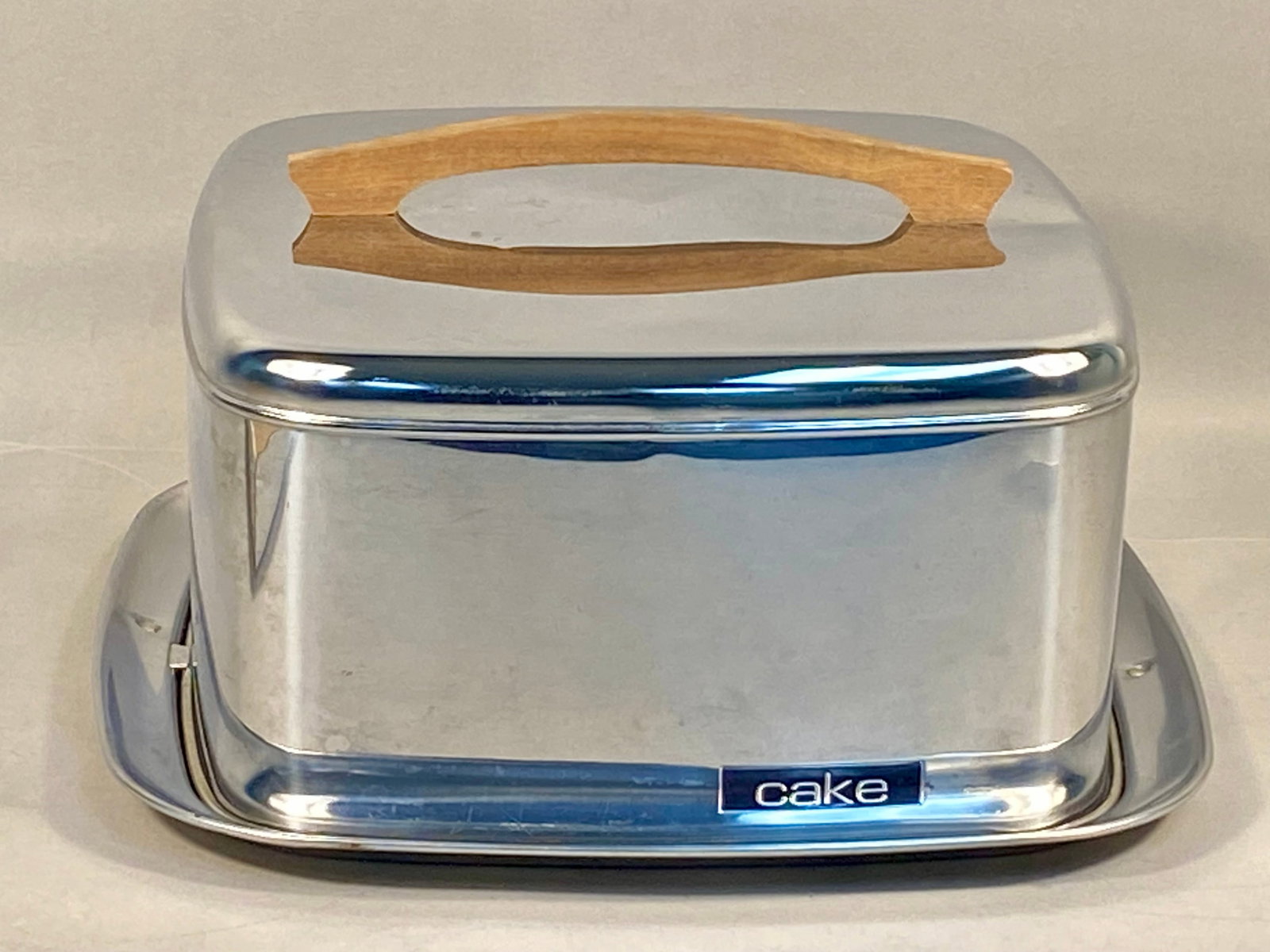 Vintage Lincoln Beautyware Square Stainless Steel Cake Carrier: A vintage Mid-Century Modern cake carrier produced by Lincoln Beautyware. The set is comprised of a square locking lid and a matching base tray, both constructed from pressed and polished stainless