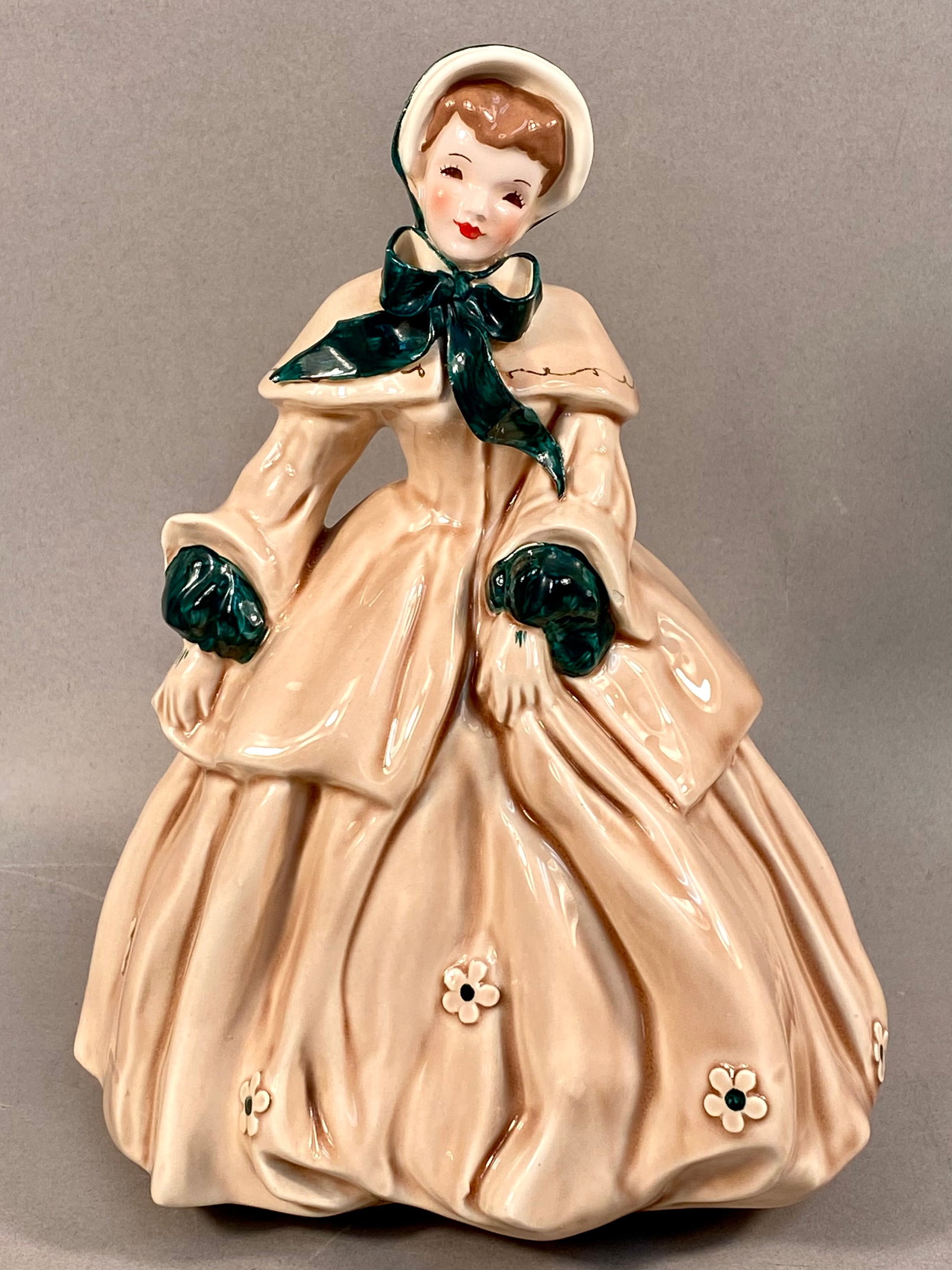 Florence Ceramics Pasadena California Abigail Figurine: A vintage ceramic figurine titled Abigail produced by Florence Ceramics of Pasadena, California. The figure depicts a woman in Victorian-style dress featuring a voluminous cream-colored gown with a ma