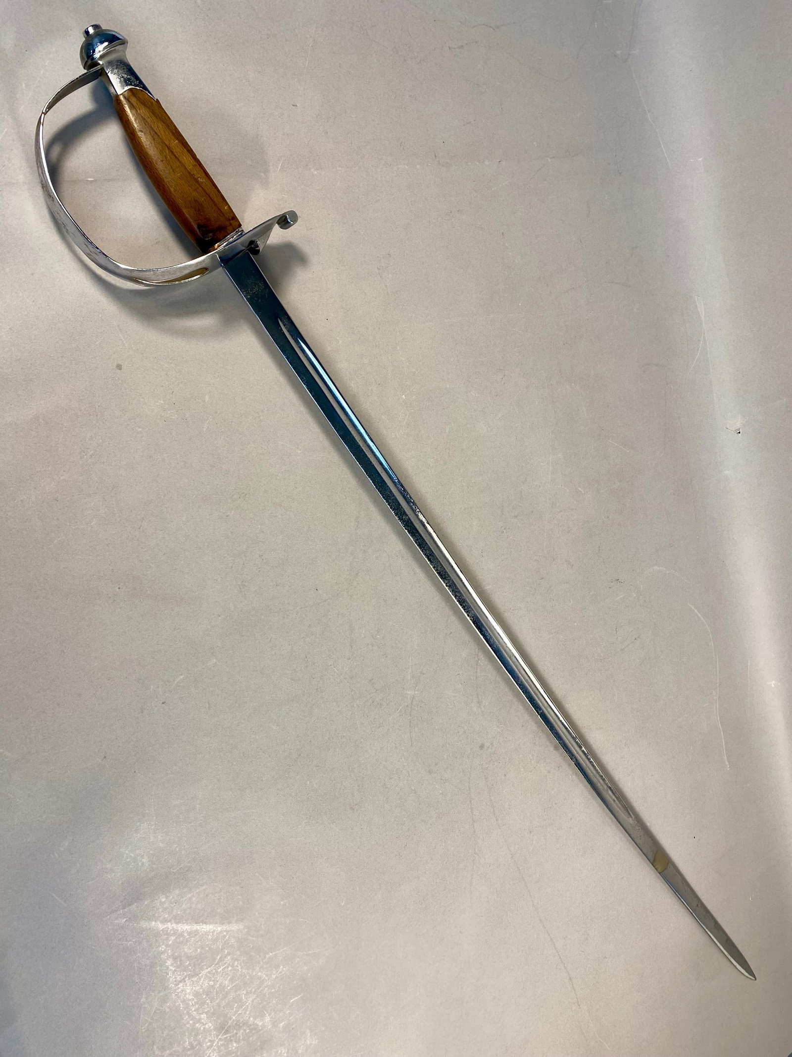 Italian Fencing Saber by Fratelli Luppi of Brescia: A vintage Italian fencing practice saber manufactured by the firm Fratelli Luppi in Brescia. The weapon features a straight steel blade designed with a single fuller and a blunted safety tip for