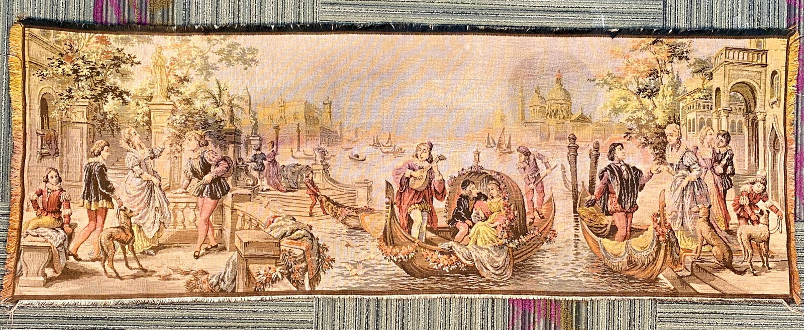 Vintage Machine Woven Jacquard Wall Tapestry: This is a machine-woven Jacquard textile wall tapestry featuring a wide-angle romanticized vista of Venice, Italy. The scene is populated with numerous figures dressed in 17th or 18th-century style