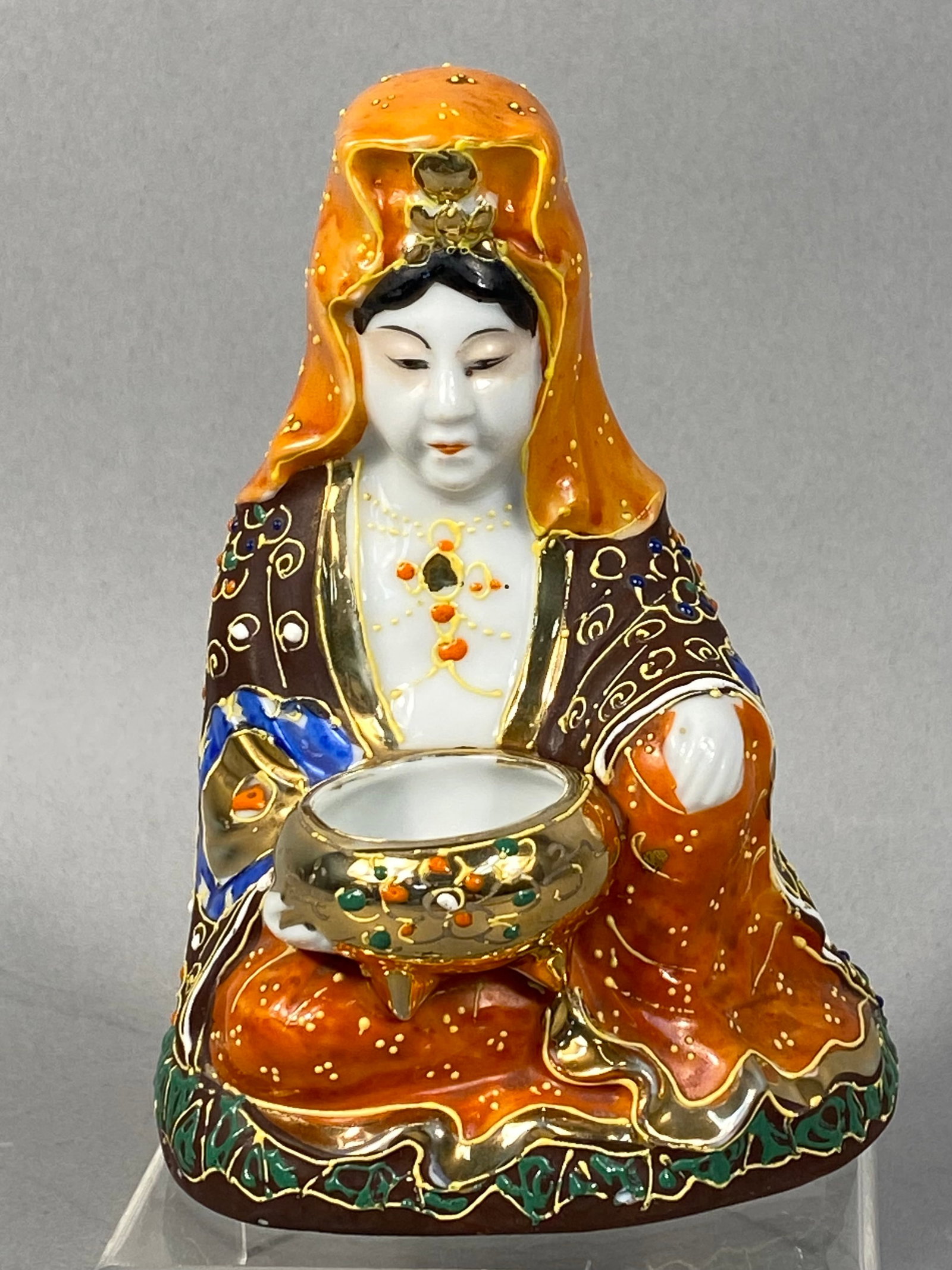 Japanese Goldcastle Chikusa Porcelain Kannon Figurine: A mid-20th century Japanese porcelain figurine produced for the export market by Goldcastle at the Chikusa factory. The piece depicts Kannon, the Buddhist deity of mercy, in a seated position holding
