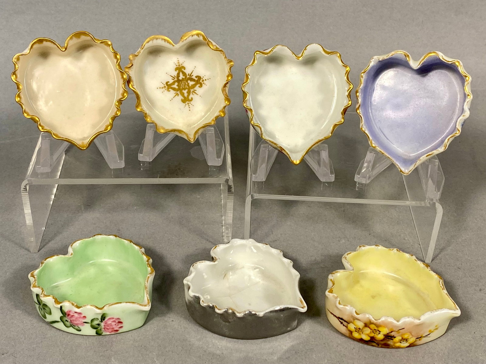 Seven T&V Limoges Hand-Painted Porcelain Heart-Shaped Dishes: A collection of seven porcelain heart-shaped dishes produced by Tressemann and Vogt (T&V) of Limoges, France. These items were likely intended for use as individual open salts, or trinket trays. Each