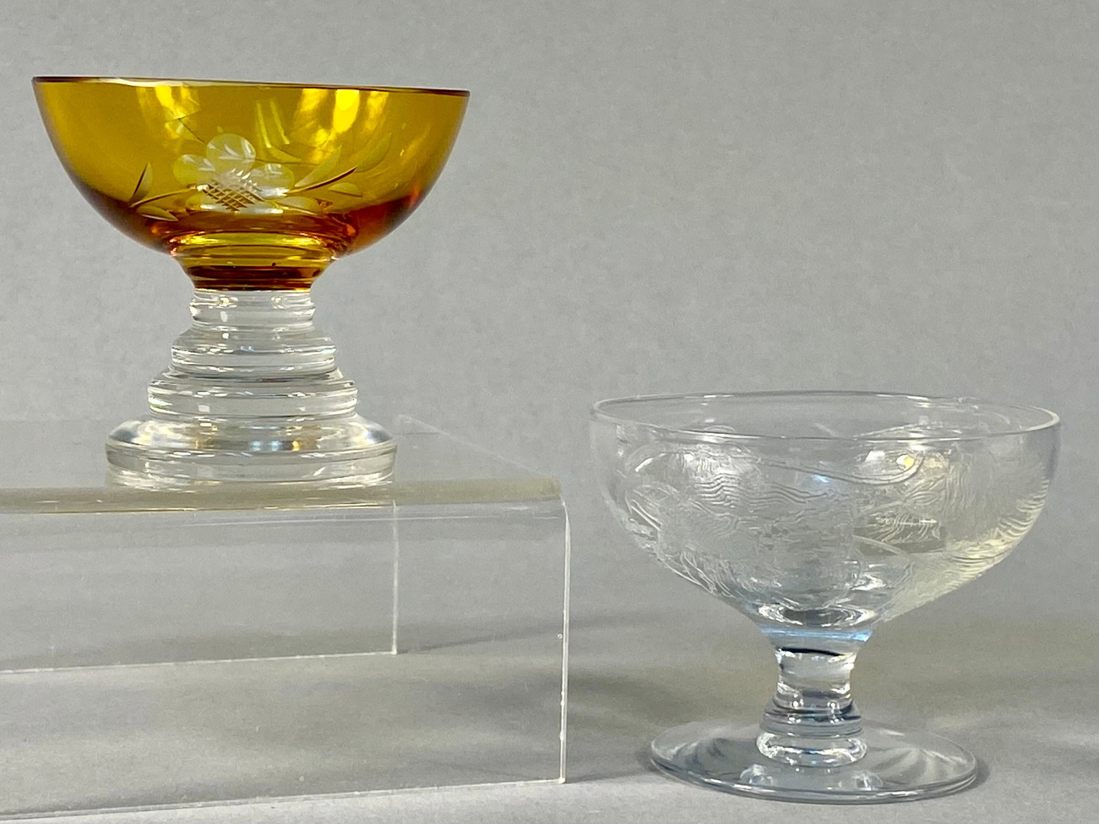 Vintage Miniature Footed Glass Bowls with Engraved & Etched Decoration: This lot features two vintage miniature footed glass bowls, likely intended as individual open salts. The first piece consists of a vibrant amber glass bowl joined to a clear glass stem and base. The 