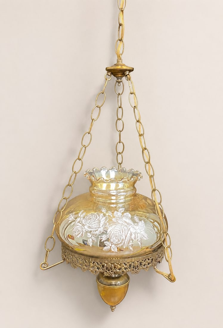 Mid-Century Victorian Style Marigold Iridescent Glass Swag Hanging Lamp: A vintage mid-century swag-style hanging lamp featuring a large marigold iridescent glass shade. The shade is designed with a ruffled upper rim and is decorated with a white transfer-printed floral