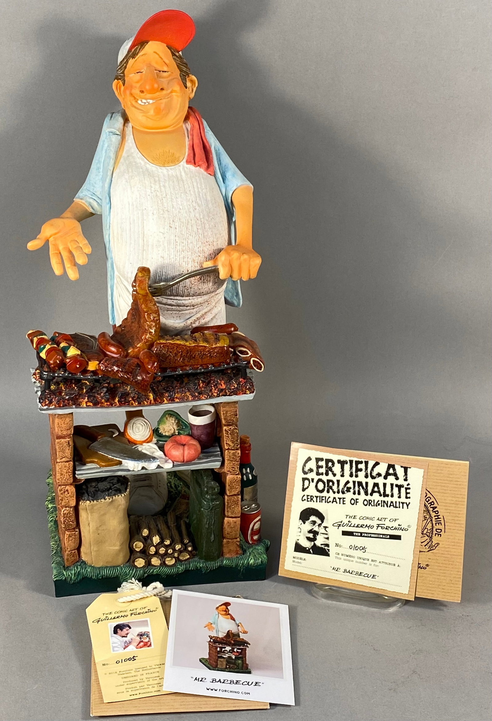 Guillermo Forchino Mr. Barbecue Hand-Painted Sculpture, No. 01005: A hand-painted polyresin caricature sculpture titled Mr. Barbecue from The Professionals series by artist Guillermo Forchino. The piece depicts a smiling man with a large belly wearing a red baseball 