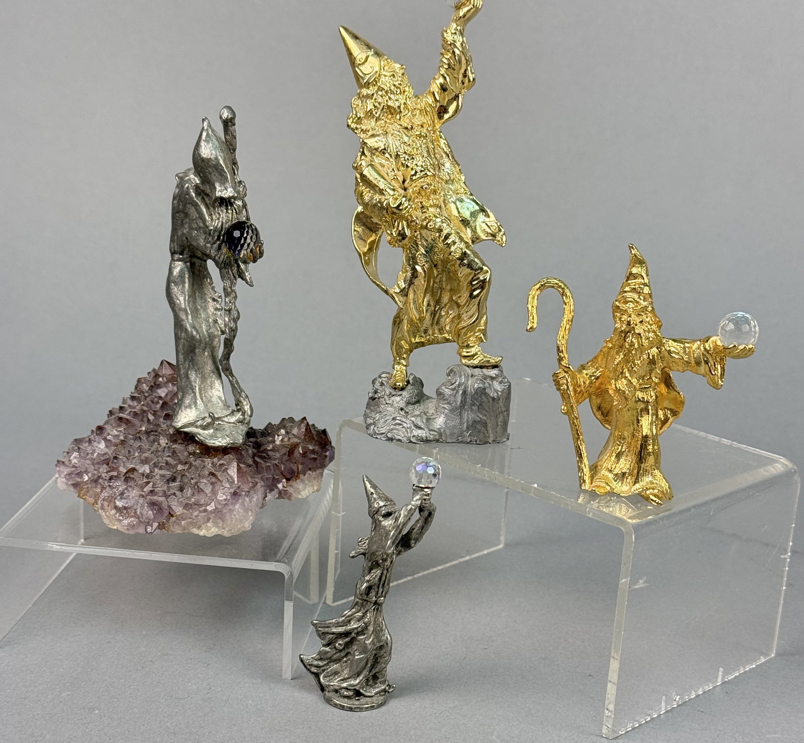 Vintage Pewter and Gold-Plated Wizard Figurines: A collection of cast metal wizard figurines featuring various finishes and decorative accents. Large gold-plated wizard height: 5 inches Amethyst base wizard height: 4 inches Small gold-plated wizard