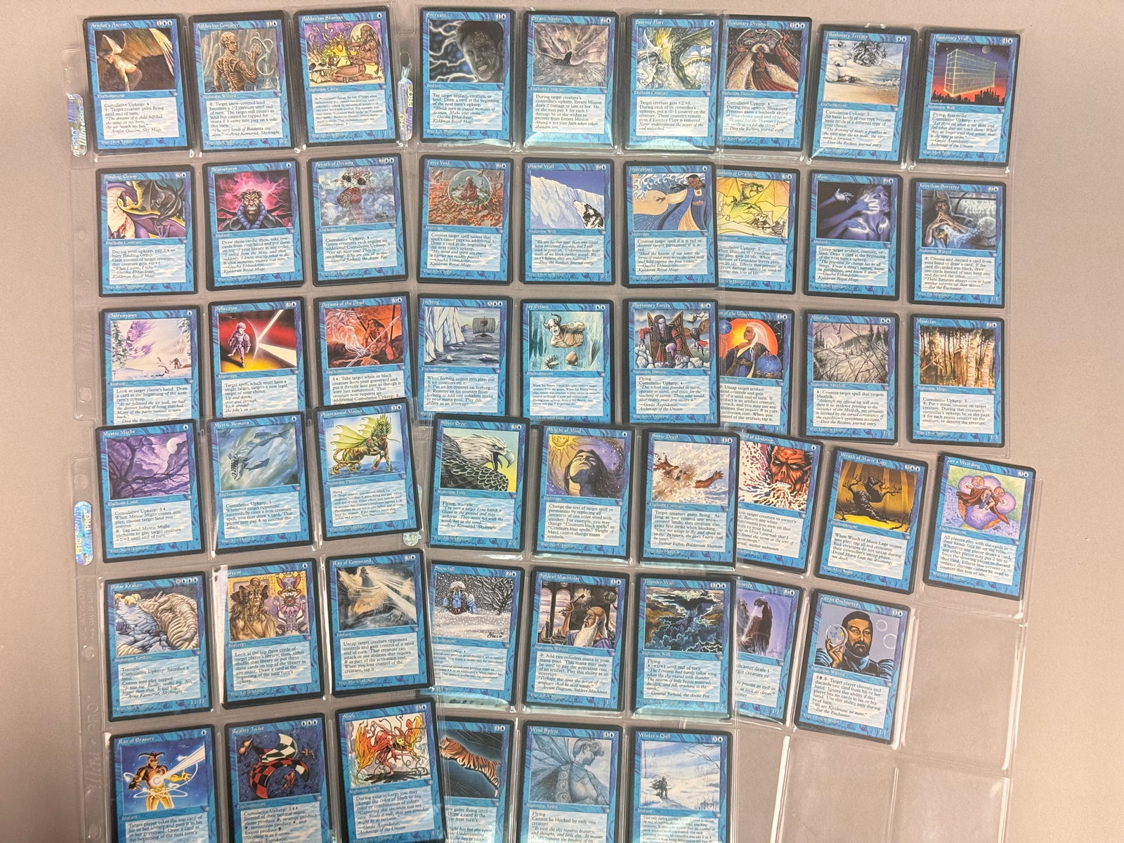 Magic: The Gathering Ice Age Blue Cards: Produced by Wizards of the Coast, this is a collection of approximately 60 vintage Magic: The Gathering (MTG) trading cards from the Ice Age expansion set, originally released in 1995. There are