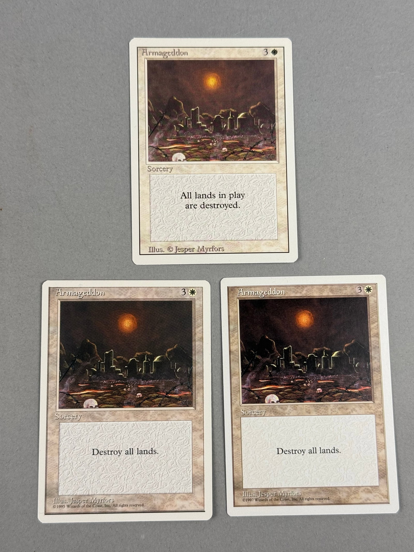 Magic: The Gathering Armageddon Revised, Fourth, and Fifth Ed: This lot features three distinct printings of the white rare sorcery card Armageddon for the trading card game Magic: The Gathering, all featuring original artwork by Jesper Myrfors. The collection in