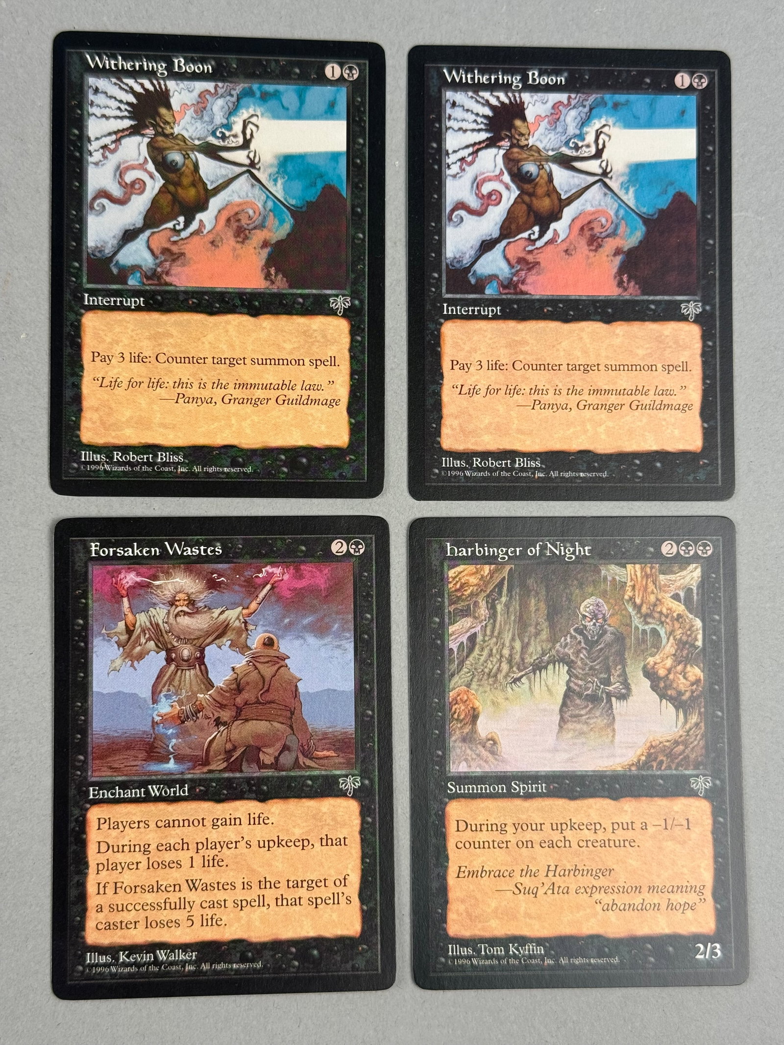 Magic: The Gathering Trading Cards from the Mirage Expansion: A collection of black-aligned trading cards from the 1996 Mirage expansion of Magic: The Gathering. The cards include the titles Withering Boon, Harbinger of Night, and Forsaken Wastes. The bottom