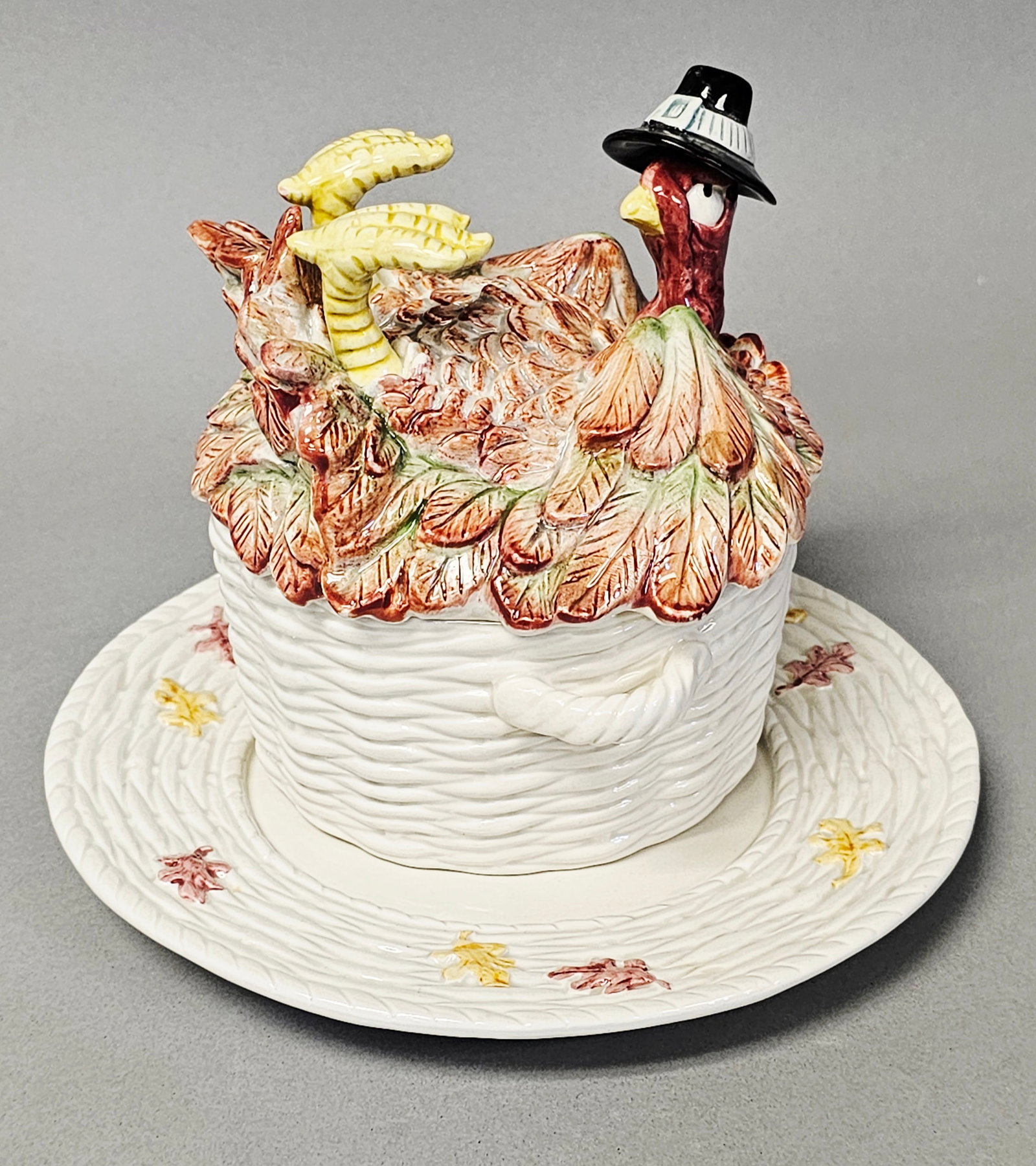 Fitz and Floyd Pilgrim's Progress Turkey Soup Bowl & Saucer: A trio of glazed ceramic pieces comprising an individual soup bowl, a sculptural lid, and a matching saucer in the Pilgrim's Progress pattern by Fitz and Floyd. Dated 1990, the set features a cream-co