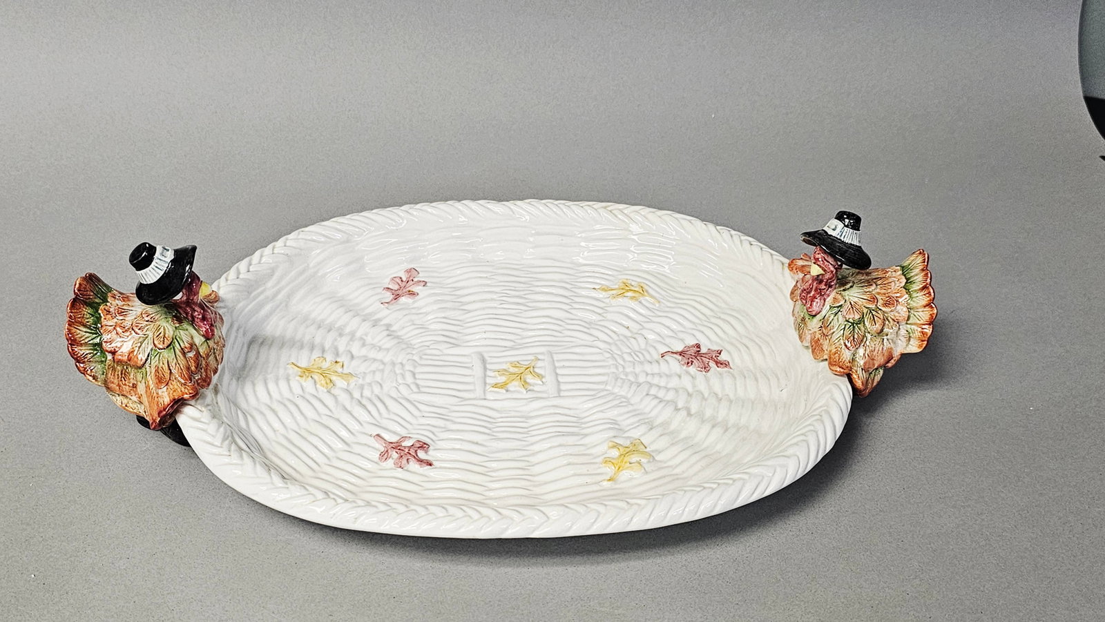Fitz and Floyd Pilgrims Progress Turkey Serving Platter: An oval earthenware serving platter by Fitz and Floyd from the Pilgrims Progress collection, dated 1990. The server features a relief-molded basketweave texture across the well and rim, decorated with