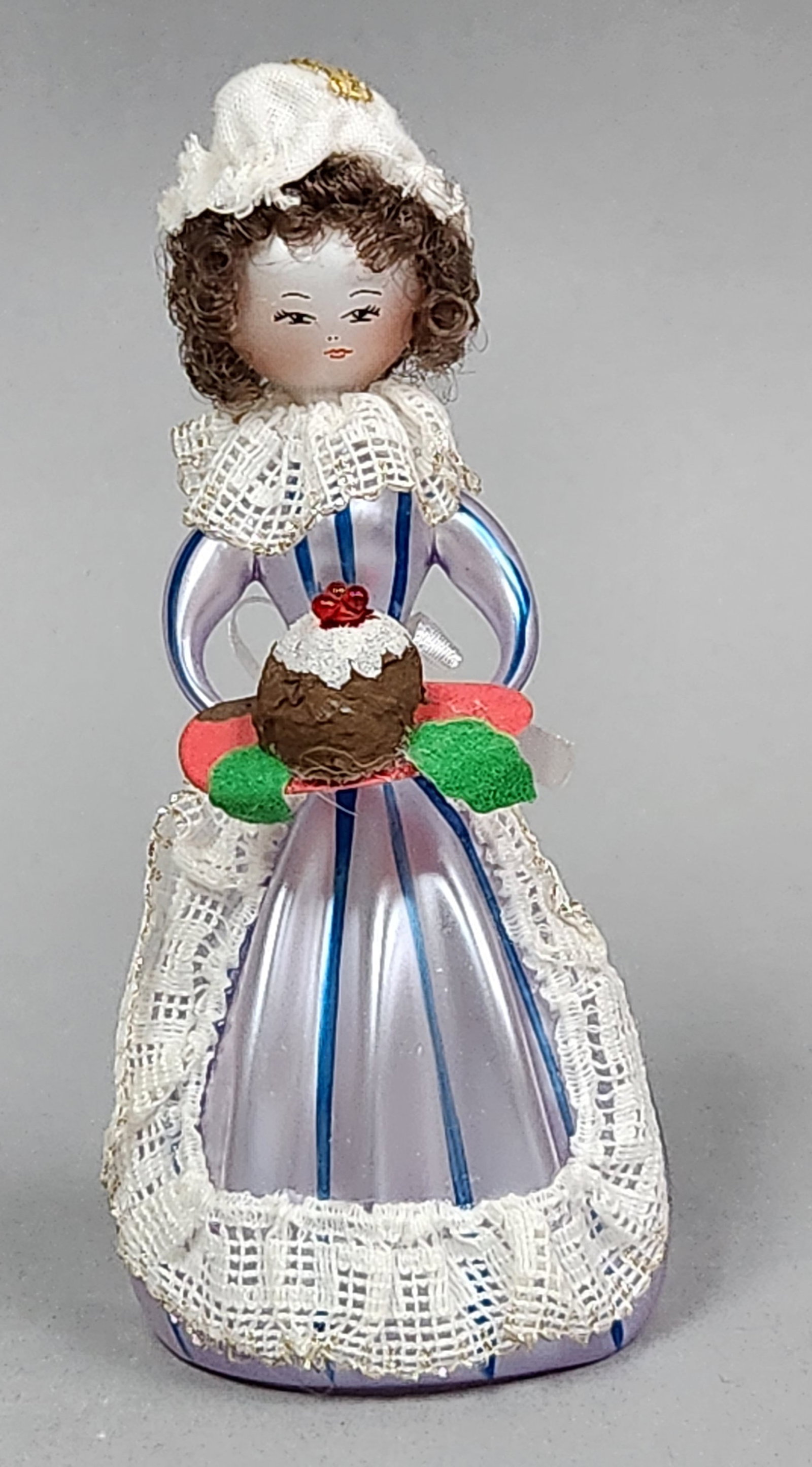 Italian Glass Victorian Woman: Stand not included. A hand-blown glass figurine representing a woman in Victorian attire holding a tray with a Christmas pudding. Height: 5.75 inches. Good vintage condition. Light fraying is noted