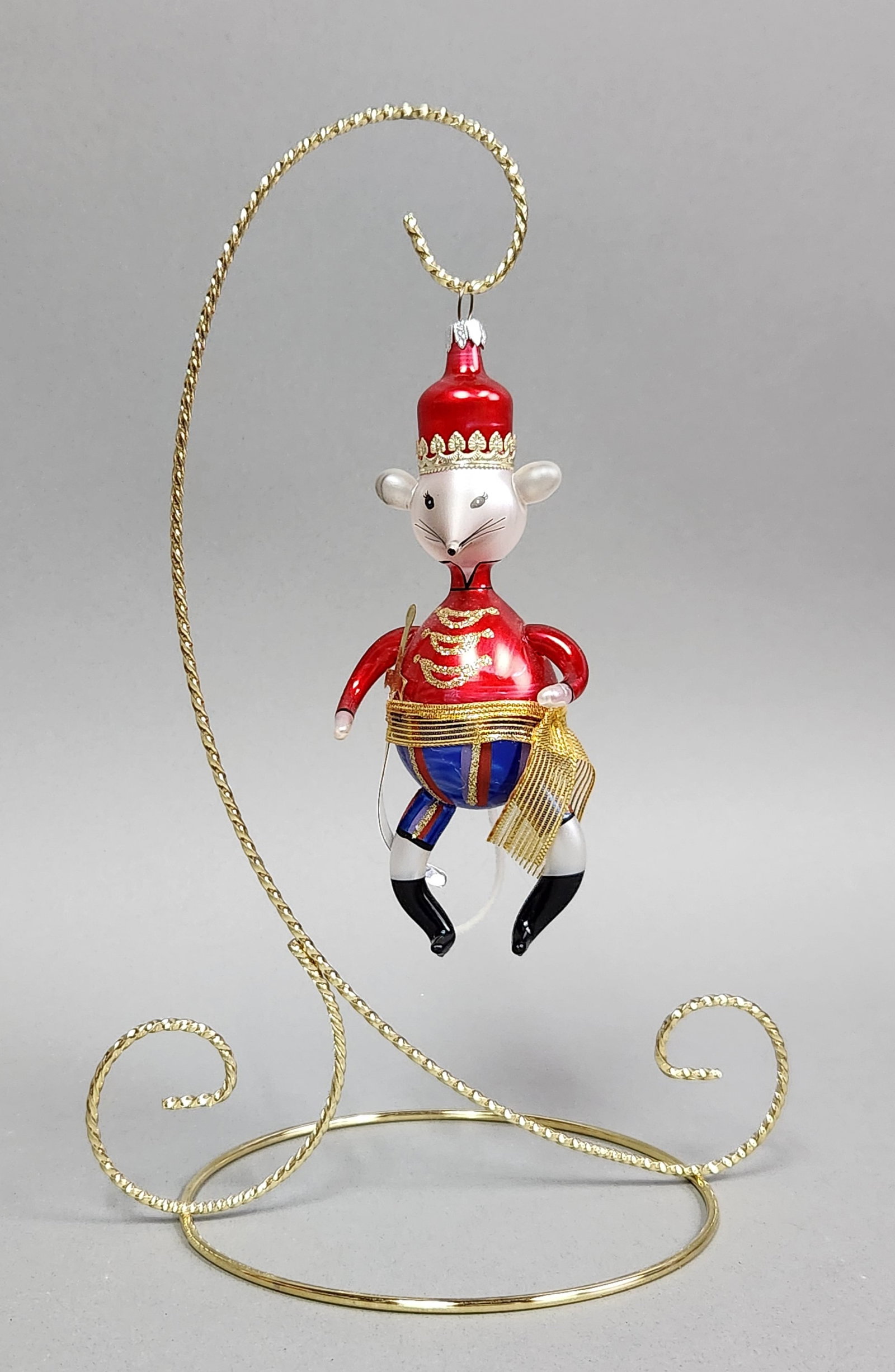 Italian Mouse Soldier Ornament: Stand not included. A blown glass mouse soldier ornament featuring a red, white, and blue uniform with gold glitter accents and fabric details, measuring approximately 5.5 inches long. Very good