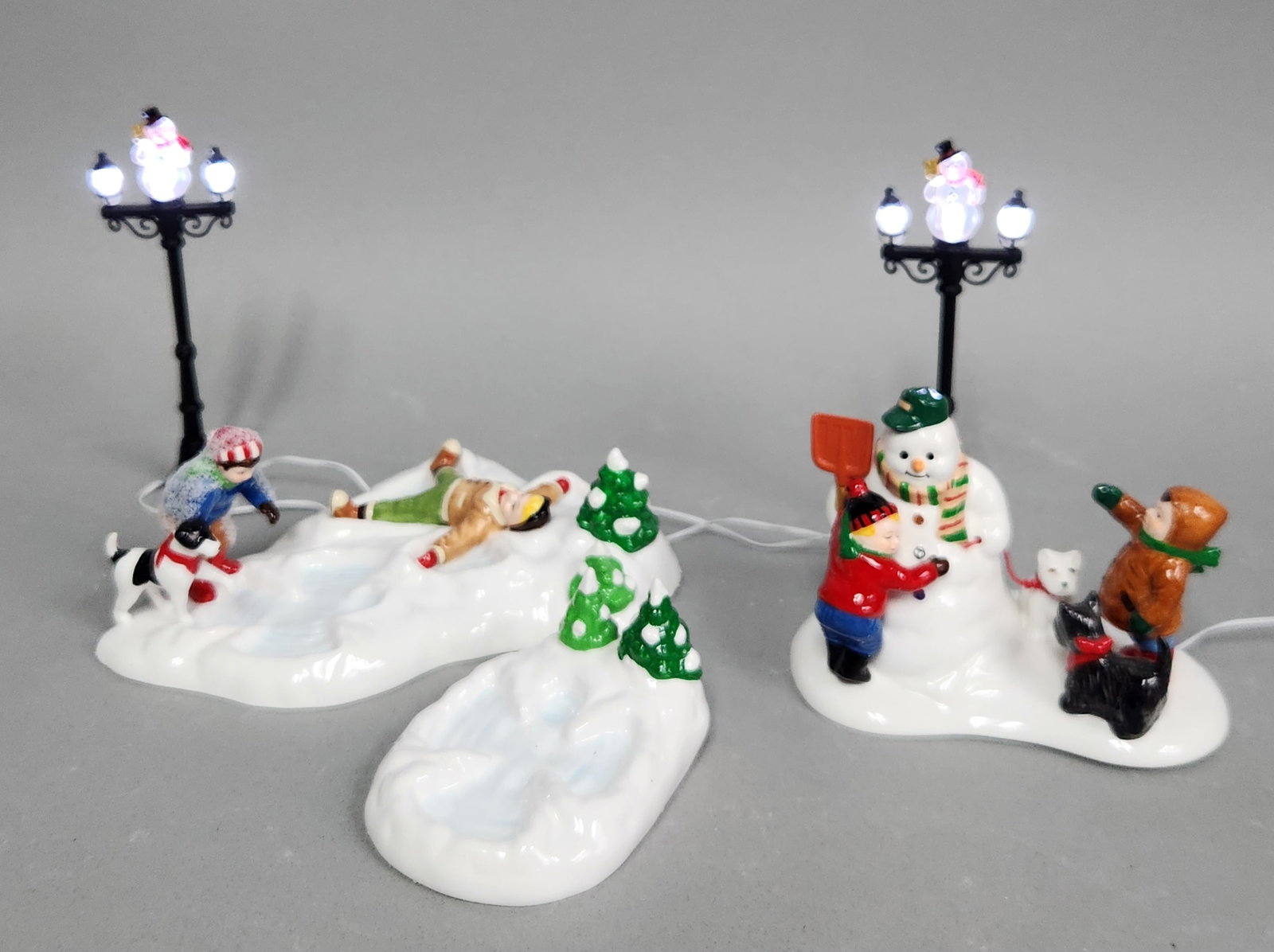 Dept 56 Snow Village Accessories: The lot includes original retail packaging for Snowman Street Lights (56.53189), Future Hockey Stars (56.55268), and Fun In The Snow (56.55125). Street lights: approximately 8.25 inches tall Snow ange