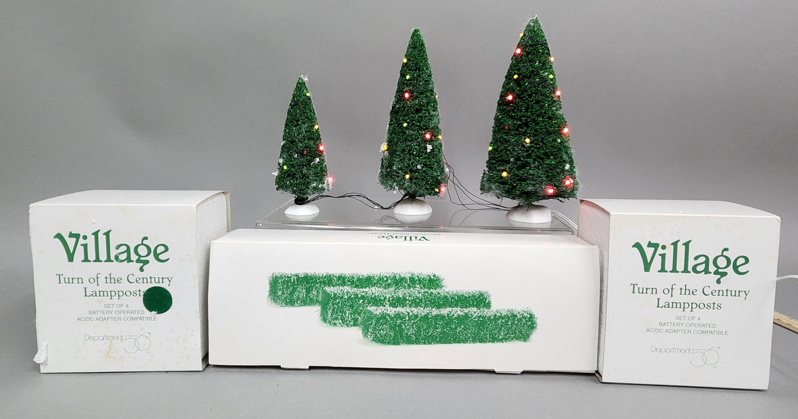 Dept 56 Village Accessories: A collection of Department 56 holiday village accessories, featuring a boxed three-piece set of Twinkling Lit Trees - Green (item #56.52823), Flexible Sisal Hedge (item #56.52662) & Turn of the