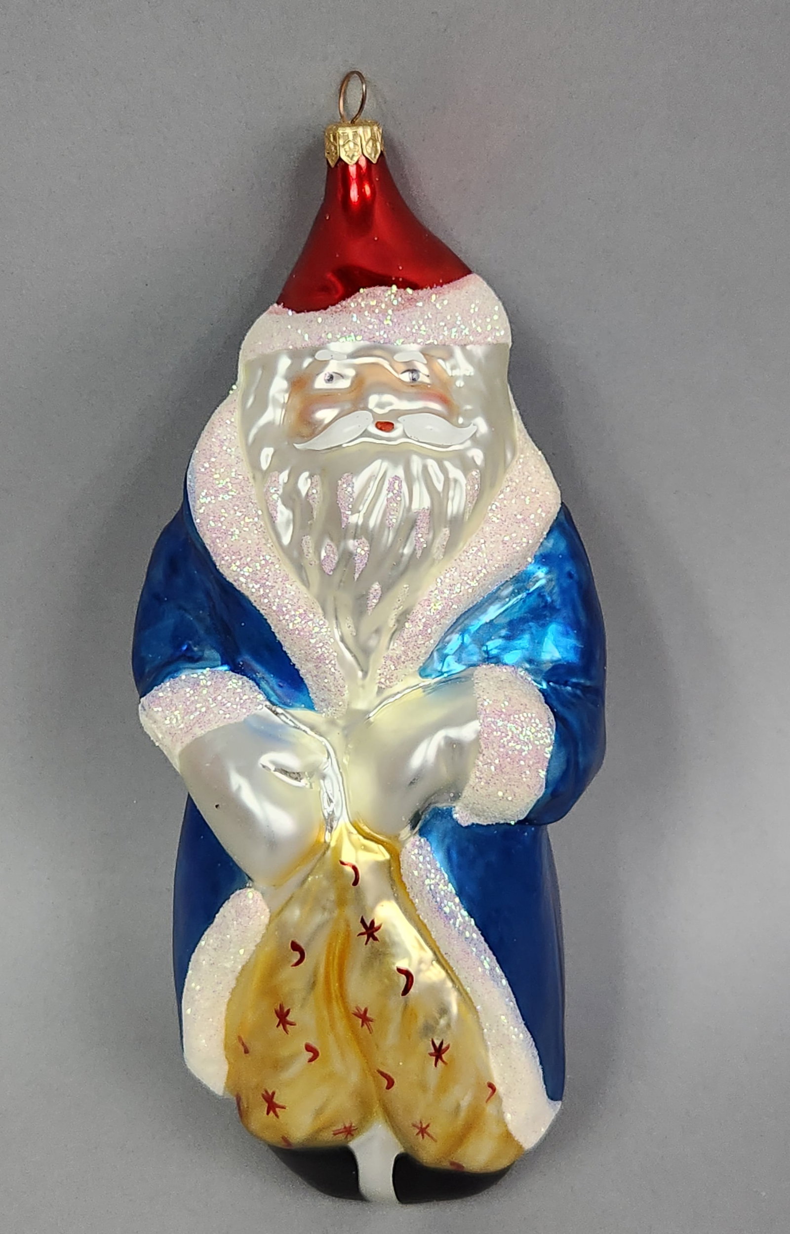 Christopher Radko Santa Claus Ornament: Stand not included. This large hand-blown glass Christmas ornament is produced by Christopher Radko. The figure depicts Santa Claus in a traditional style. Length: approximately 11 inches.The item is