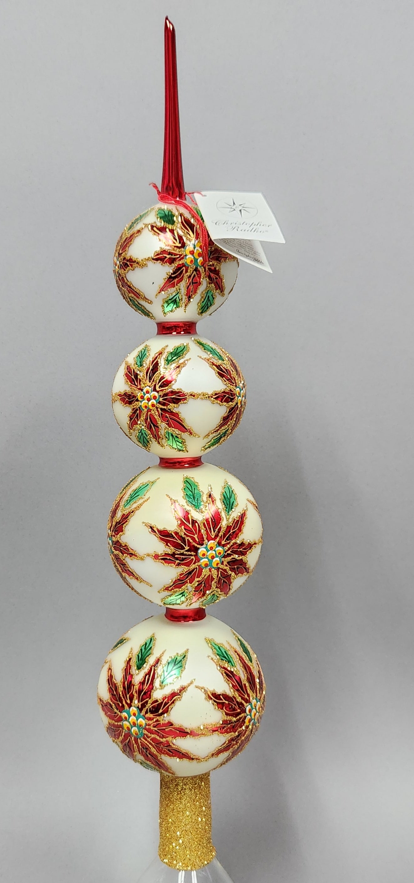 Christopher Radko Poinsettia Finial: A Christopher Radko Poinsettia Blossom Finial, model number 11206-1, hand-painted blown glass Christmas tree topper. Length: Approximately 18 inches. The piece is in good condition with no apparent