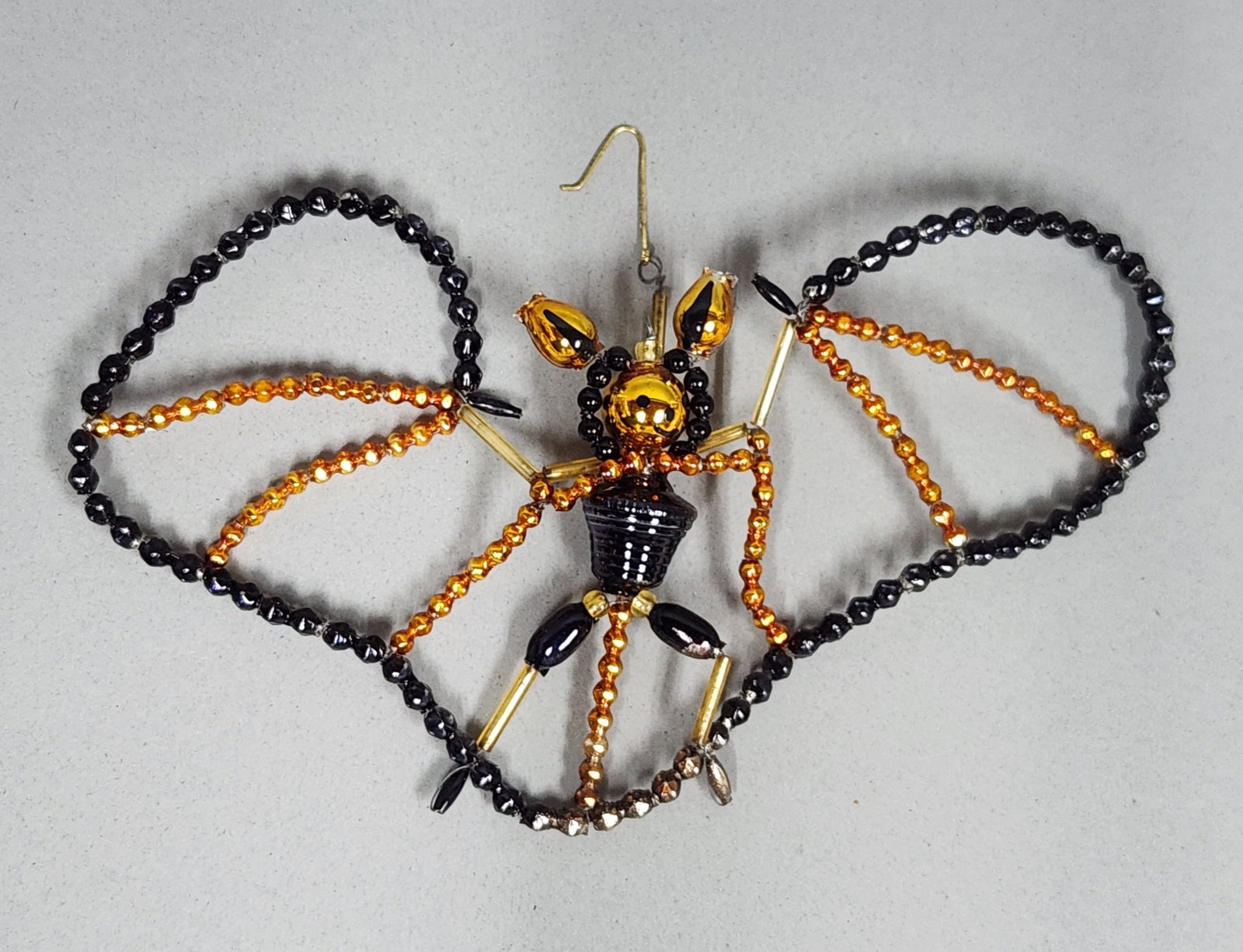 Christopher Radko Beaded Butterfly Ornament: Stand not included. Christopher Radko butterfly shaped ornament composed of black, gold, and amber toned glass beads on a wire frame, measuring approximately 7.5 inches wide. Very good condition.