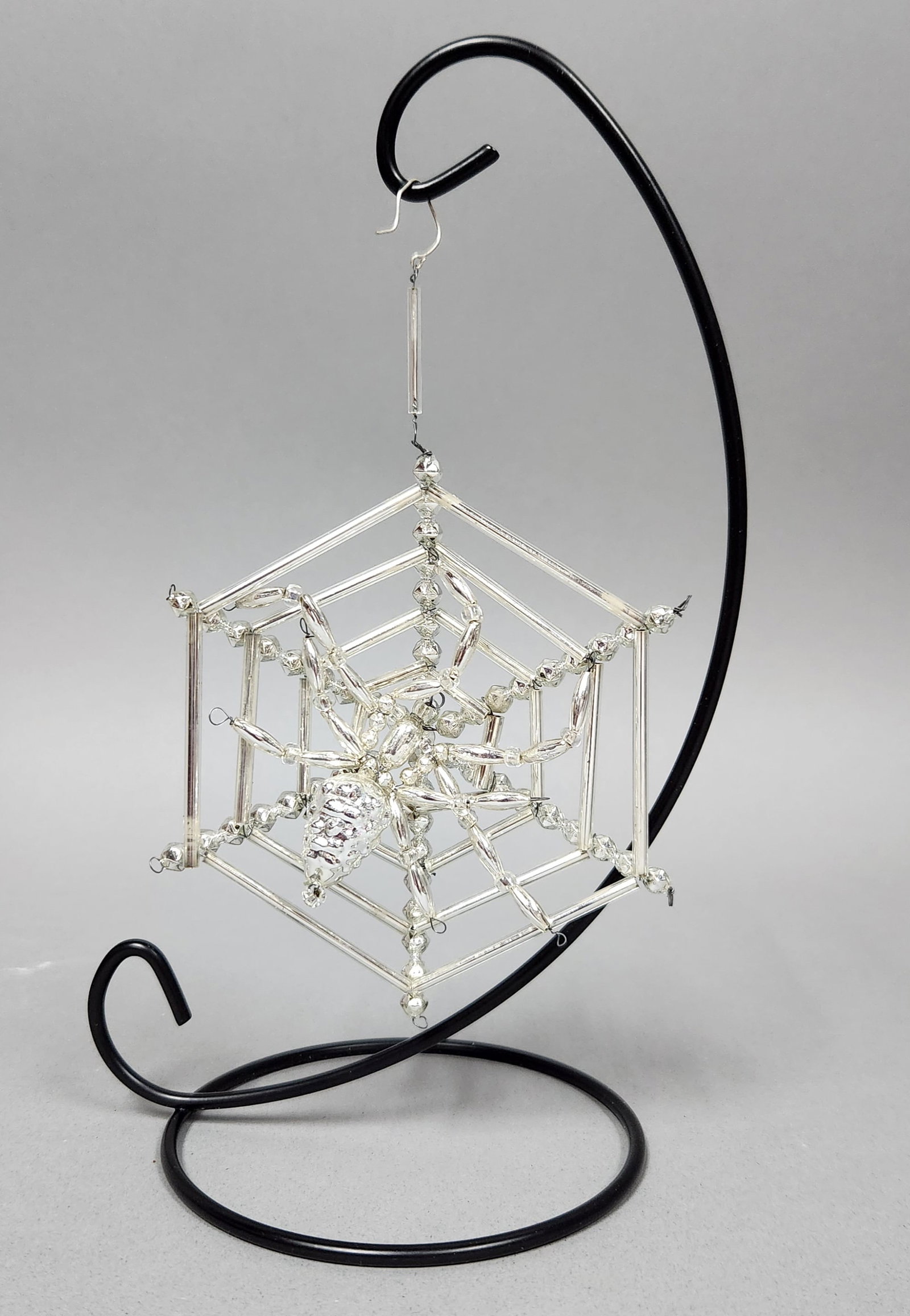 Santa Land Spider Web Ornament: Stand not included. Santa Land silver-toned glass bead ornament featuring a spider on a hexagonal web. Width: approximately 4.5 inches. The ornament appears to be in good condition. No missing beads