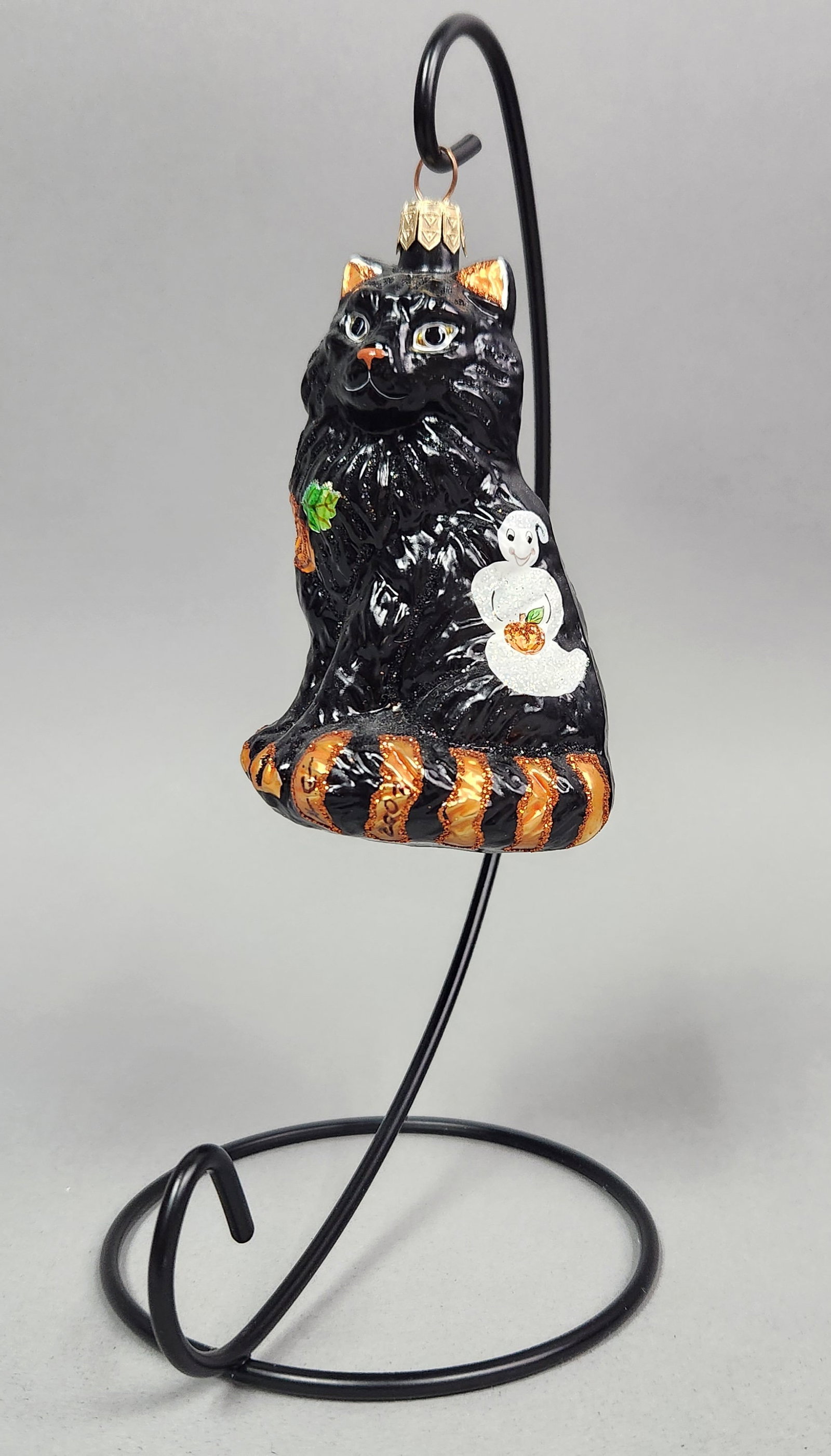 OWC Black Cat Ornament: Stand not included. Old World Christmas hand-painted blown glass ornament in the form of a seated black cat with a textured surface. Height: 5 inches. The ornament is in good overall condition with
