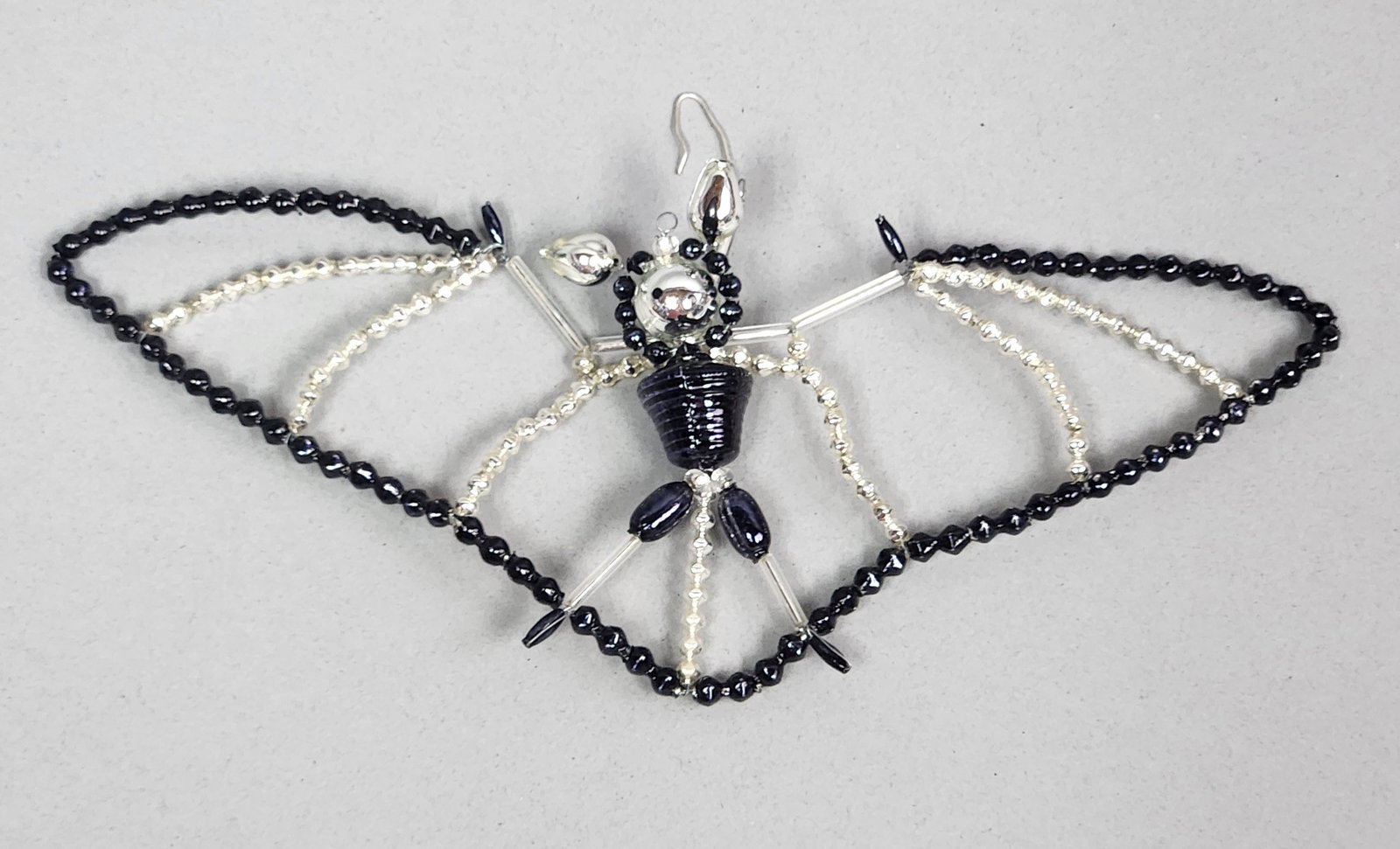 Radko Ding Bat Ornament: Stand not included. Christopher Radko Ding Bat glass ornament. Width: Approximately 7.5 inches. The ornament is in good overall condition with no visible missing beads or broken wires. Minor surface