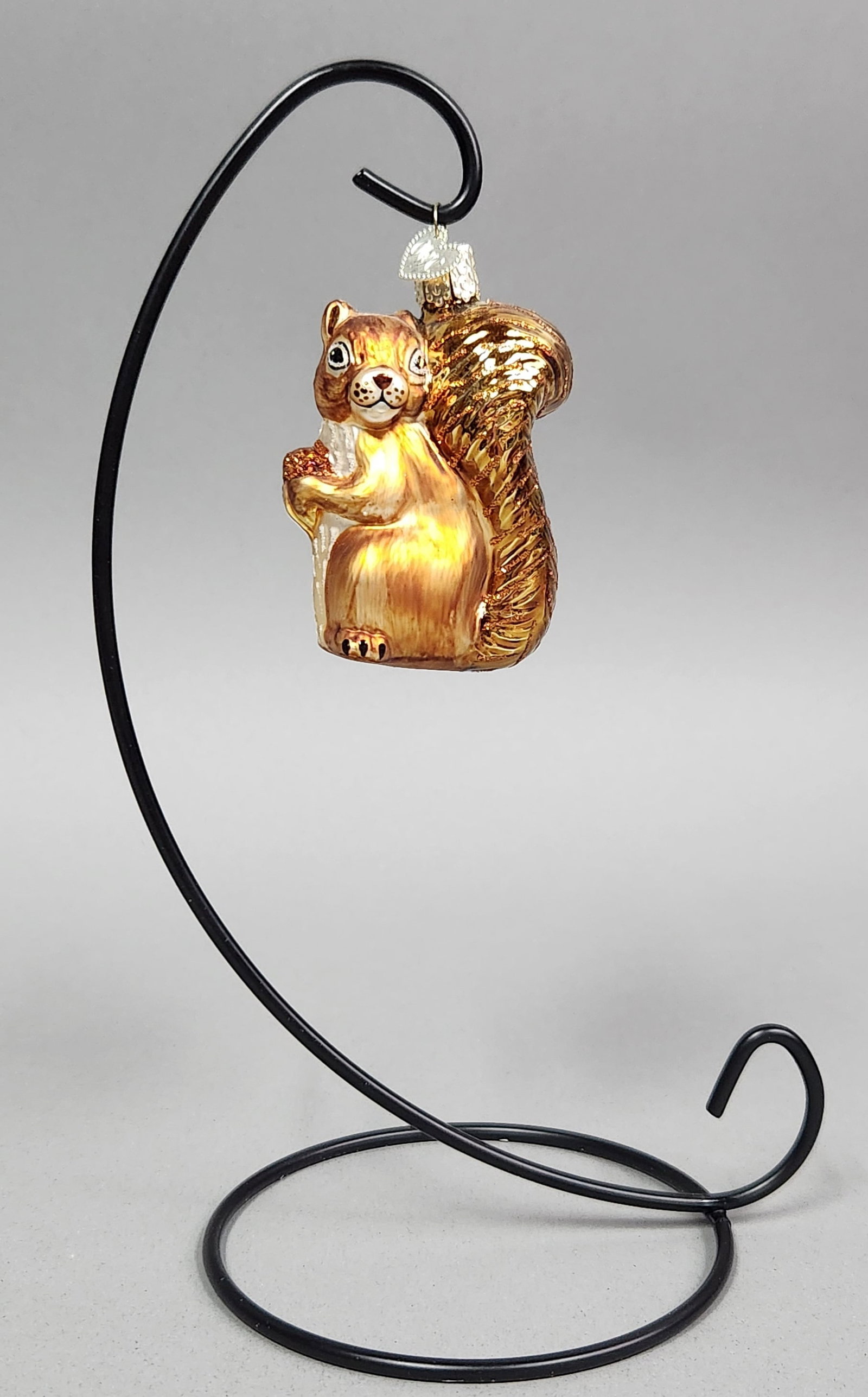 OWC Squirrel Christmas Ornament: Stand not included. Old World Christmas blown glass squirrel Christmas ornament features golden-brown and bronze tones with glitter accents and a metal OWC heart charm, measuring approximately 3