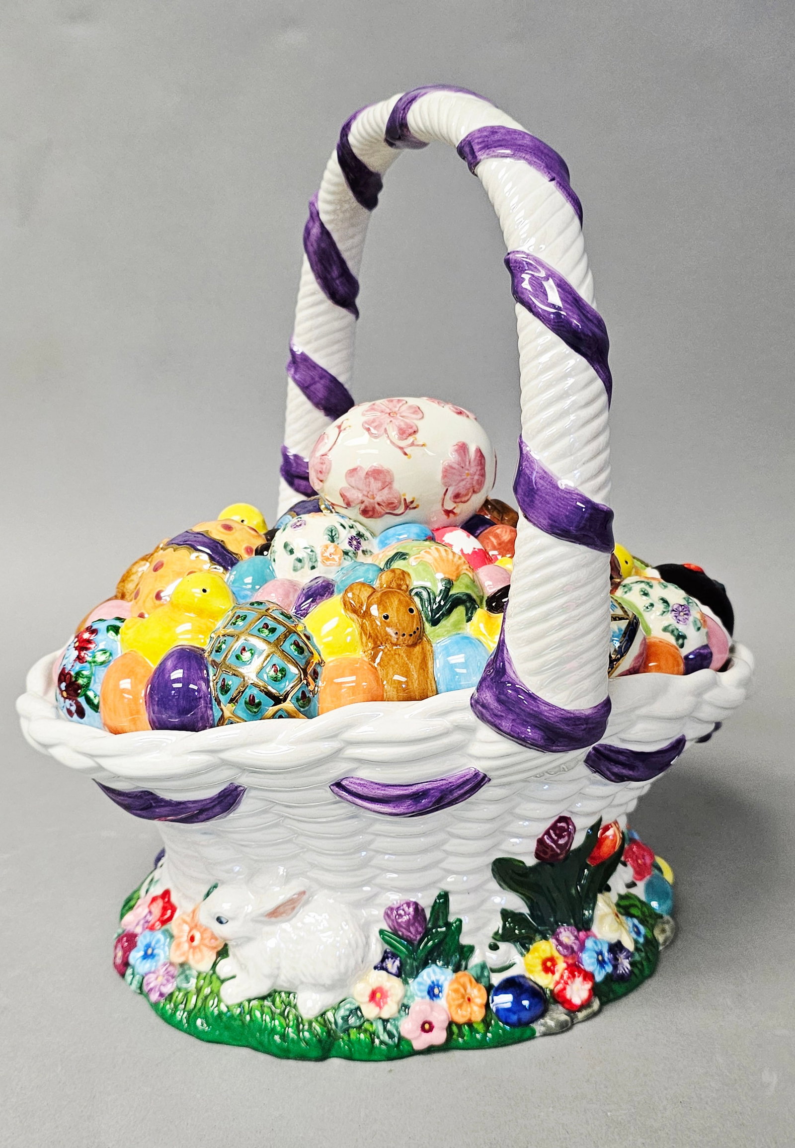 Christopher Radko Lidded Ceramic Easter Egg Basket: A large lidded ceramic Easter basket produced by Christopher Radko. The piece is constructed from glazed earthenware in two parts: an oval-shaped bowl and a highly dimensional lid. The lid is densely