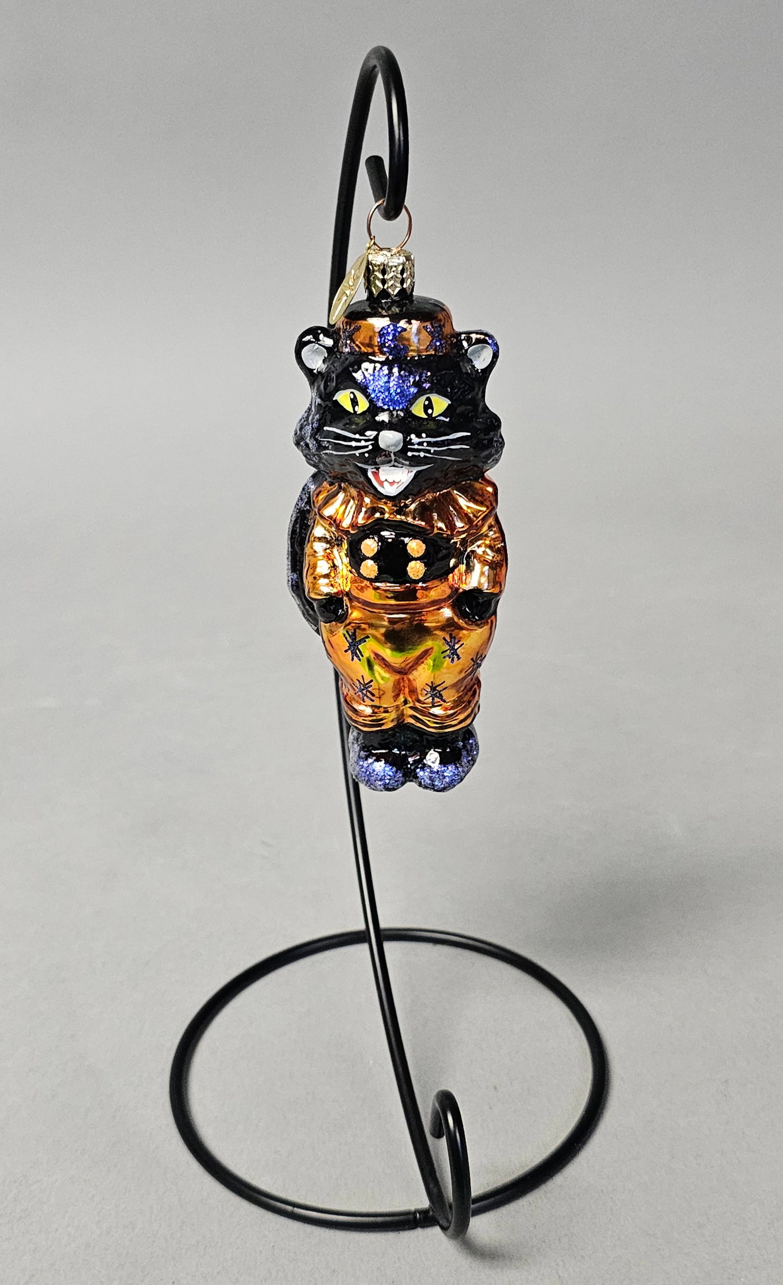 Radko Witchy Whiskers Halloween Ornament: *STAND NOT INCLUDED* Christopher Radko Witchy Whiskers hand-painted, mouth-blown glass holiday ornament. The figurine depicts an anthropomorphic black cat standing upright, dressed in a festive Hallow