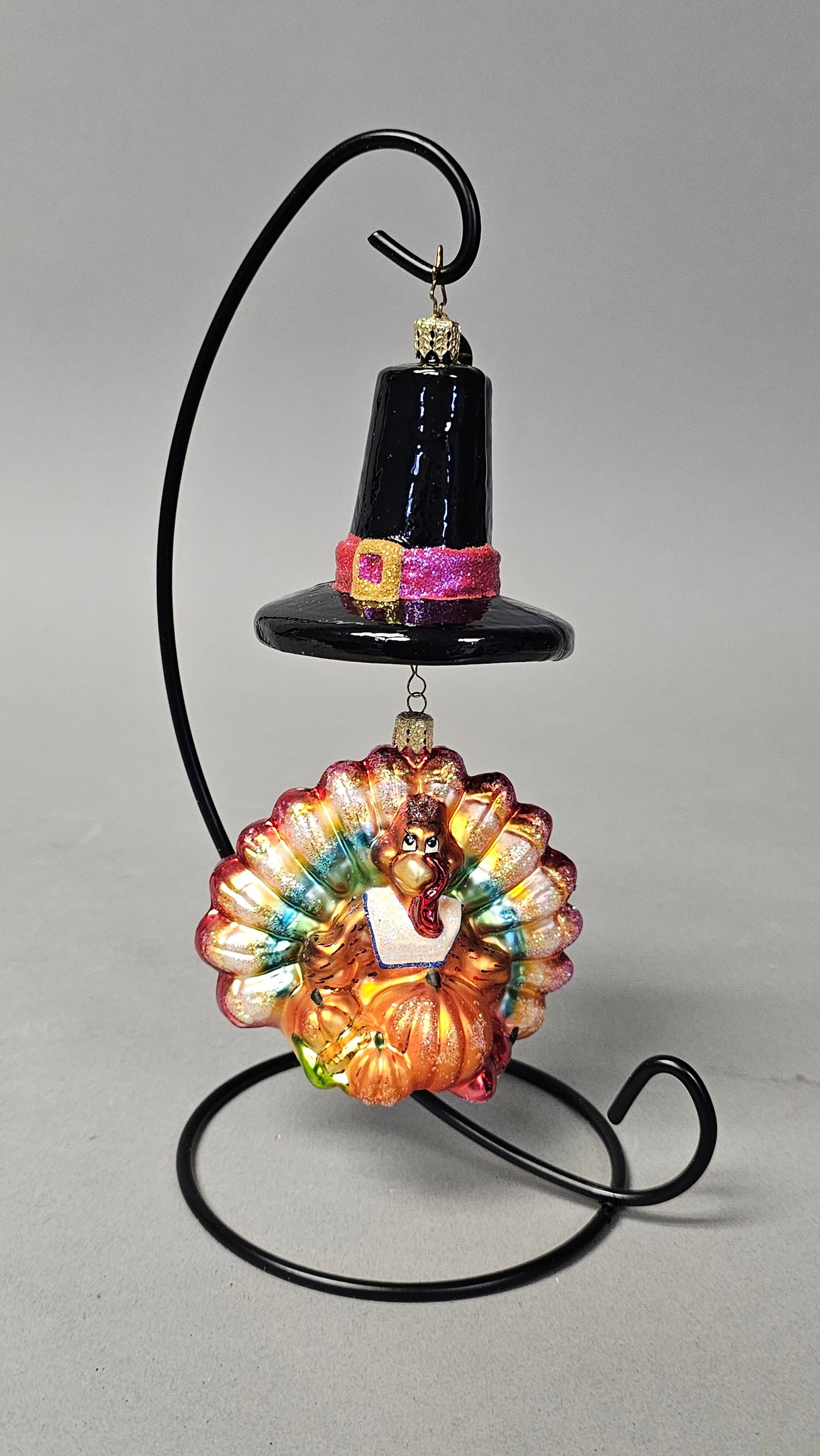 Christopher Radko Thanksgiving Turkey Ornament: *STAND NOT INCLUDED* A mouth-blown glass holiday ornaments by Christopher Radko, featuring a Thanksgiving theme. The assembly includes a top ornament shaped as a black pilgrim hat and a bottom