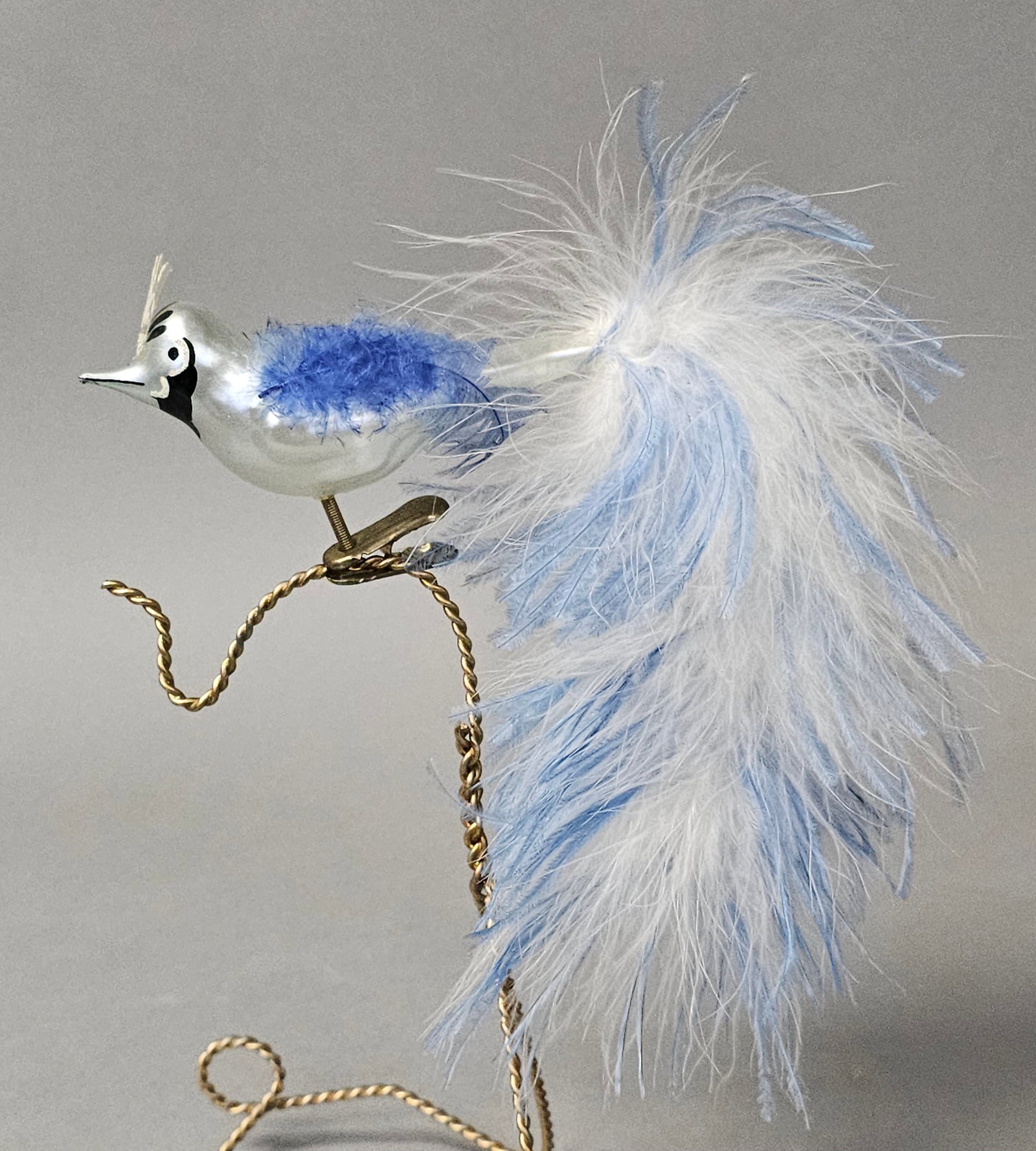 Italian Blown Glass Clip-on Bird Christmas Ornament: *STAND NOT INCLUDED* A vintage Italian blown glass bird Christmas ornament. The ornament features a silvered glass body with hand-painted facial details in black and white. It is decorated with a