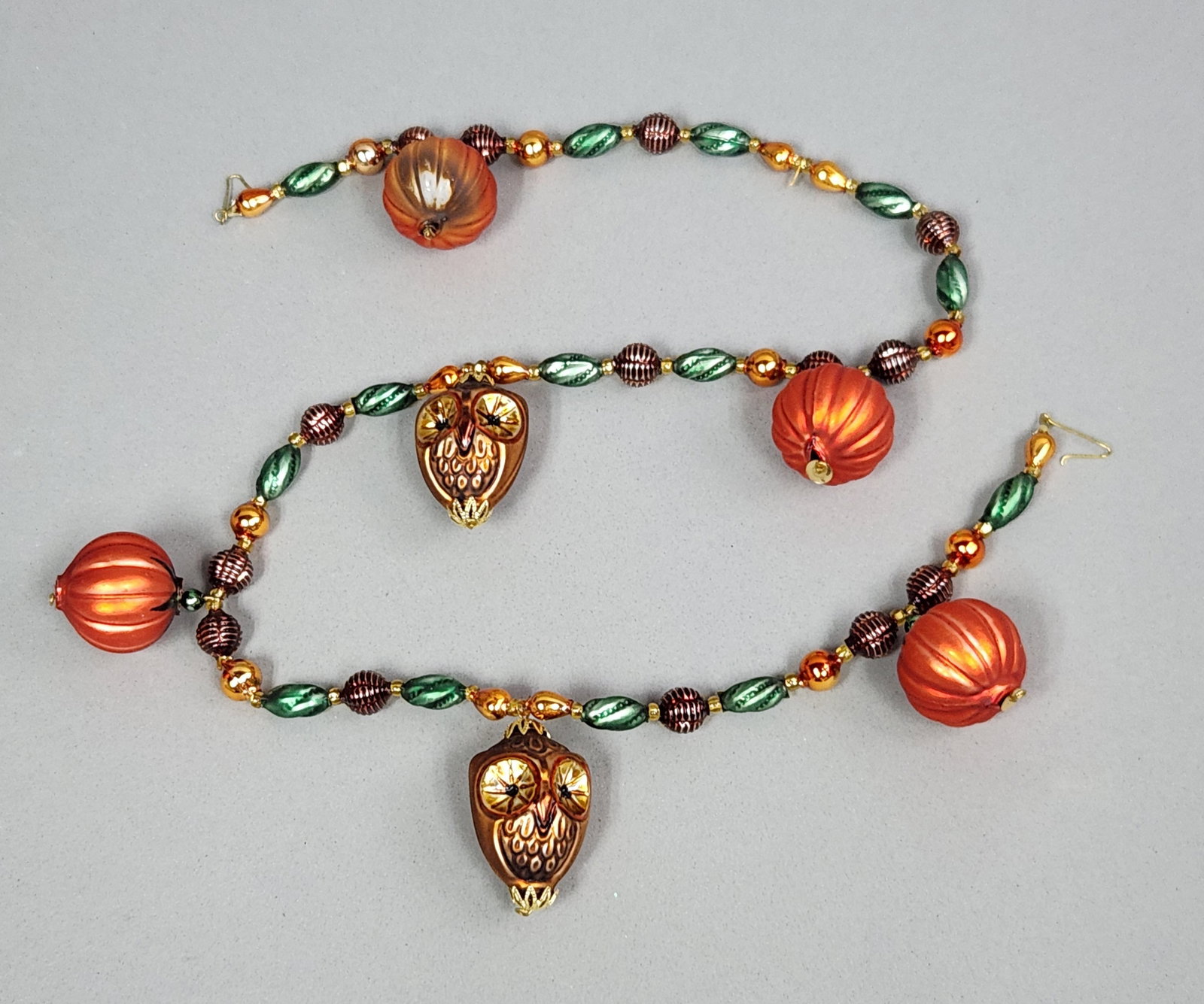 Radko Autumn Bead Garland: A Christopher Radko blown glass bead garland featuring an autumn theme. The strand is composed of multiple hand-blown glass ornaments in the form of pumpkins and owls. Length: 36 inches. One of the