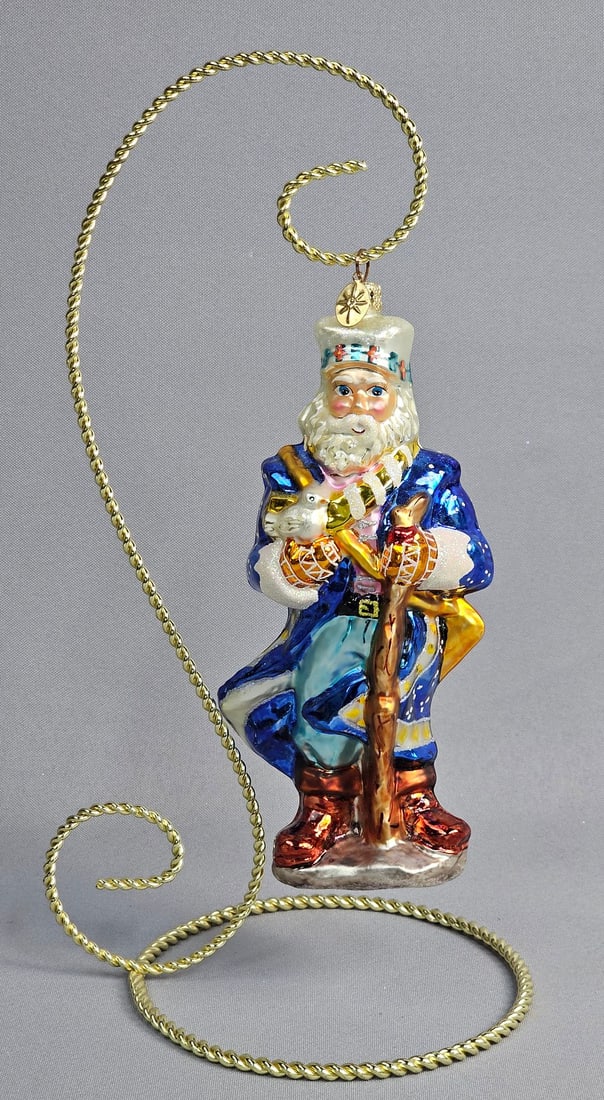 Radko Siberian Santa Blown Glass Christmas Ornament: *STAND NOT INCLUDED* A Christopher Radko hand-painted blown glass Christmas ornament depicting a Siberian Santa figure. The top of the ornament is finished with a gold-toned metal cap embossed with th