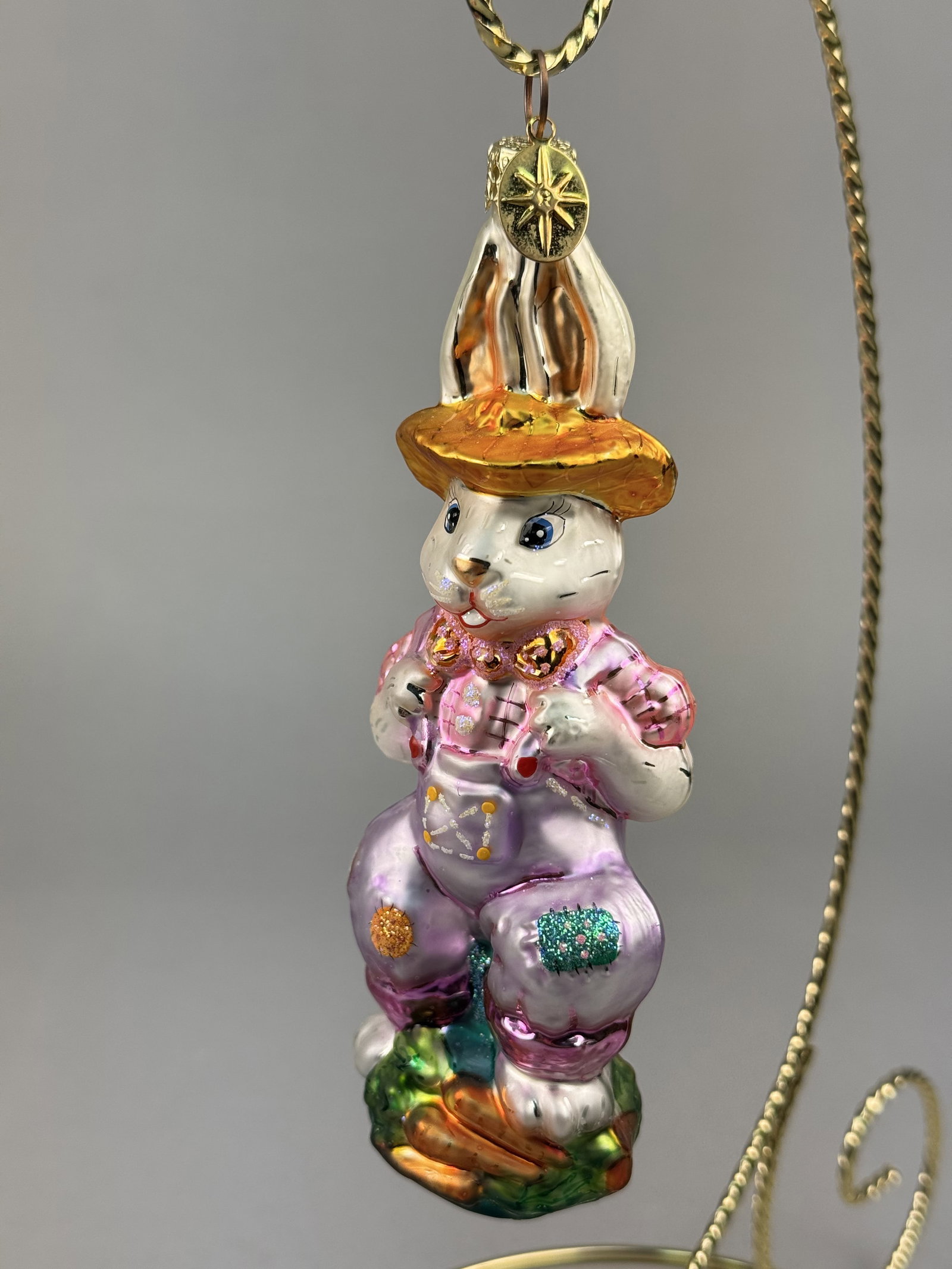 Radko Hilly Billy Bunny Glass Ornament 2001: Stand not included. This mouth-blown glass holiday ornament by Christopher Radko is identified as the Hilly Billy Bunny model. The piece is finished with hand-painted details and fine glitter highligh