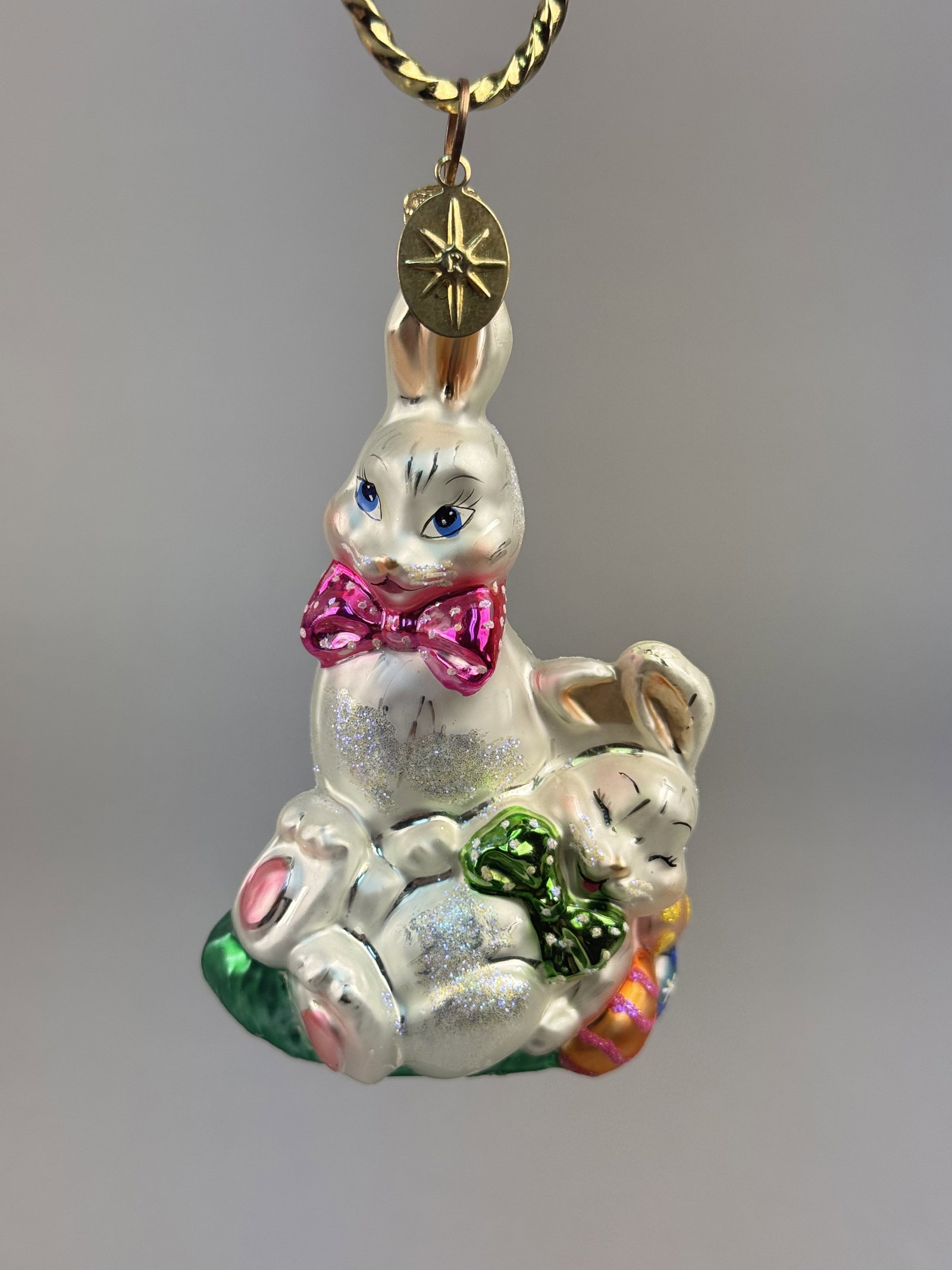 Radko Bunny Snooze Hand Blown Glass Easter Ornament: Stand not included. A Christopher Radko hand-blown glass Easter ornament titled Bunny Snooze. TThe ornament is fitted with the signature Christopher Radko gold-toned crown cap and a circular metal han