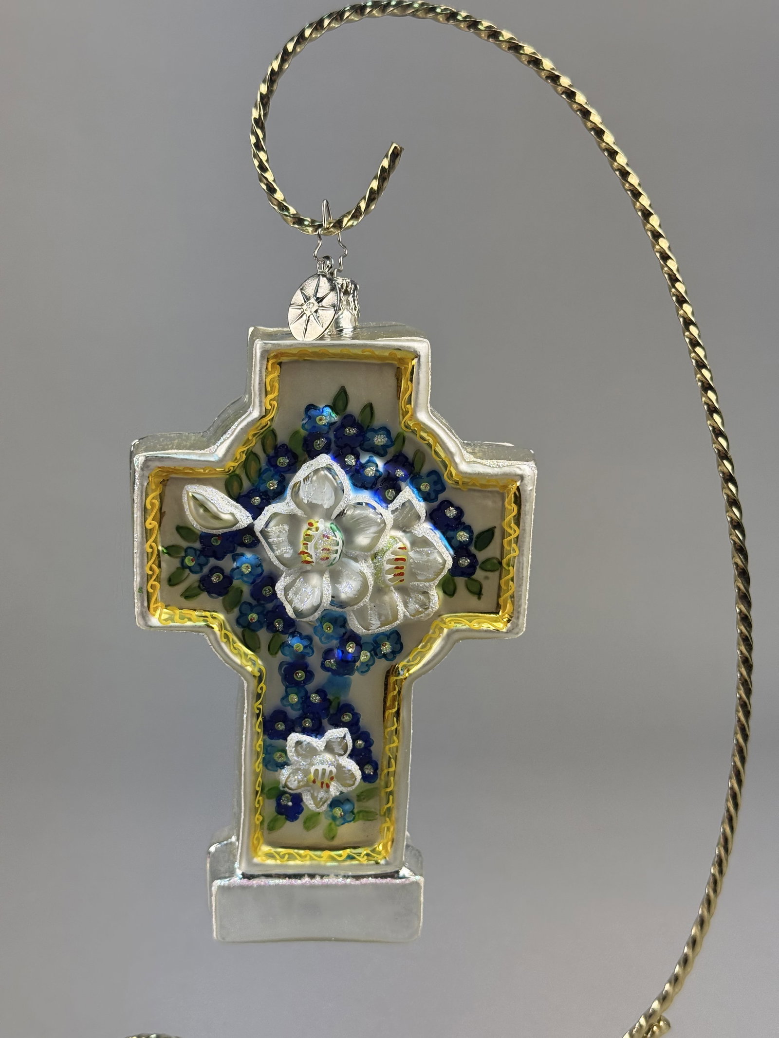 Radko Blown Glass Floral Cross Christmas Ornament: Stand not included. A hand-blown glass Christmas ornament by Christopher Radko, featuring a floral cross design. . The ornament includes a silver-toned metal cap and hanging loop with an attached