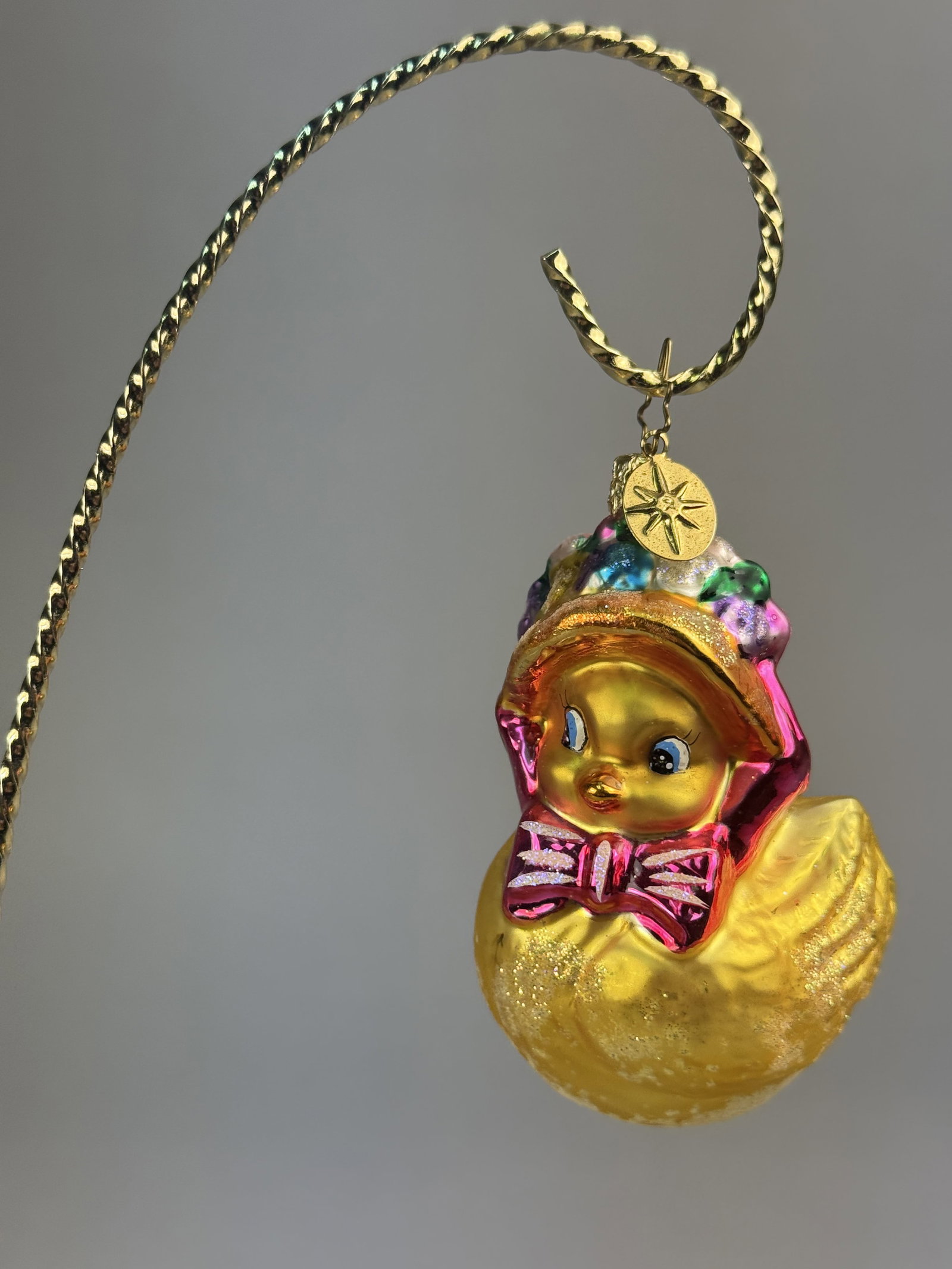Radko Blown Glass Easter Duckling Ornament: Stand not included. Christopher Radko Li'L Tweet hand-painted blown glass holiday ornament depicting a yellow duckling. The piece includes a gold-tone metal starburst charm attached to the hanging loo