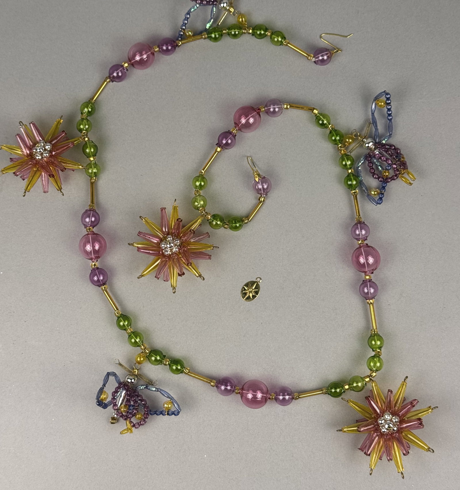 2001 Christopher Radko Daisy Days Beaded Flower and Dragonfly Glass Garland: This beaded decorative garland is identified as the Daisy Days pattern by Christopher Radko. l oval gold-tone metal charm embossed with an eight-pointed starburst, the signature logo for Christopher R