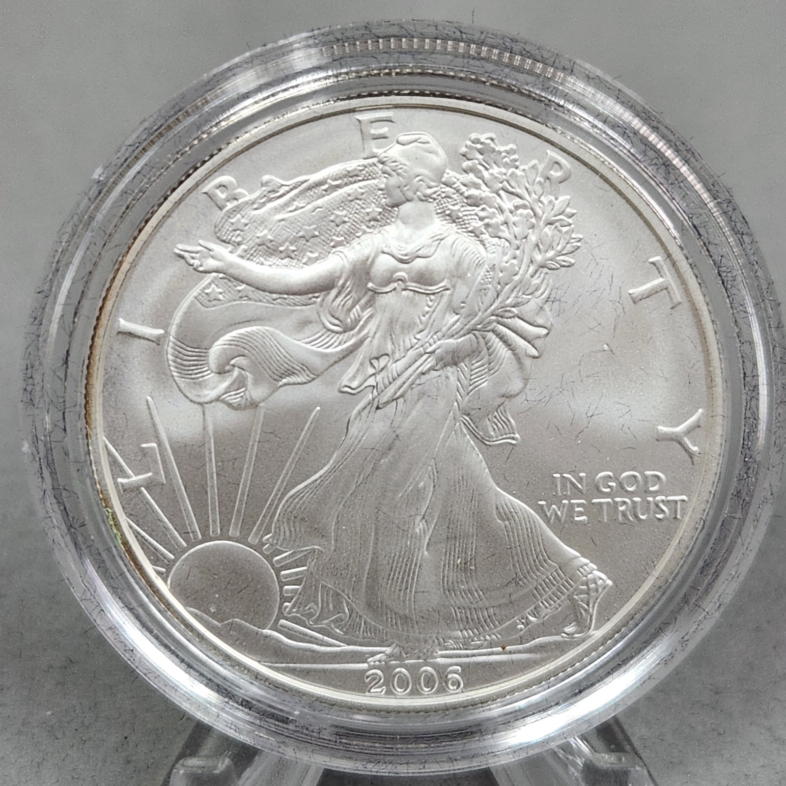 2006 American Eagle $1 Coin 31 Grams: This lot features a 2006 US American Silver Eagle one dollar coin. Struck at the West Point Mint, the coin bears a W mint mark on the reverse, identifying it as the uncirculated collector version (bur
