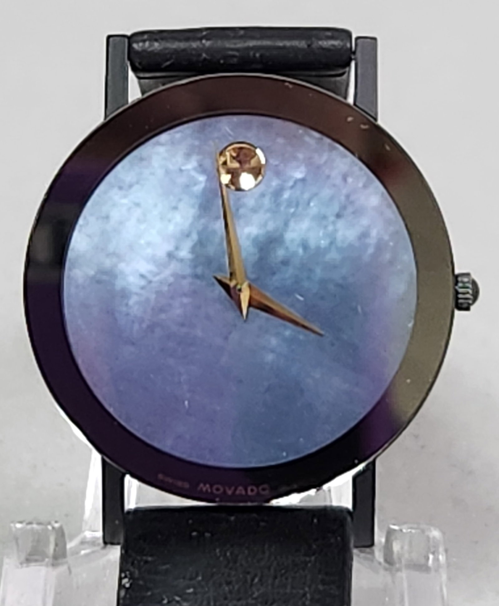 Movado Museum Watch #87-40-882N: This Swiss-made Movado Museum Ultra Thin wristwatch features a distinctive iridescent mother-of-pearl dial in shifting shades of blue and purple. The brushed metal case back is engraved with the refer