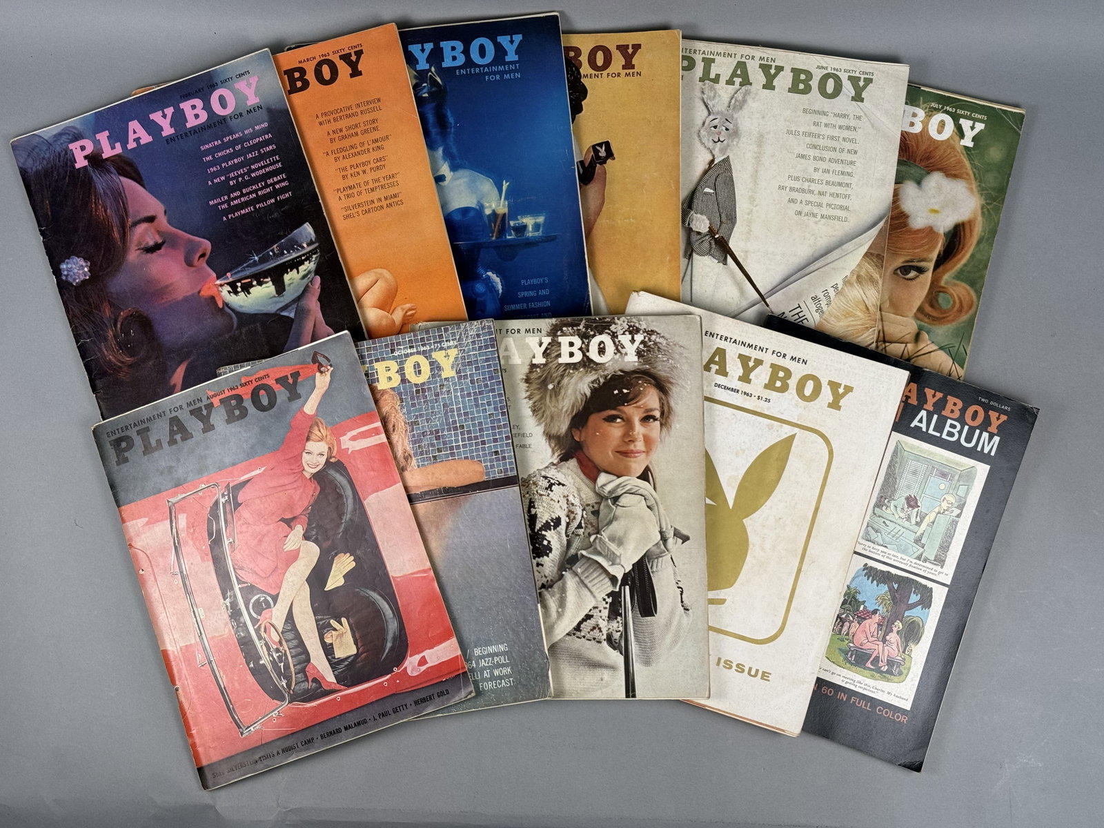 Eleven Vintage Playboy Magazines 1963: This collection consists of eleven vintage publications published by HMH Publishing Co., Inc. The lot includes ten monthly issues of Playboy magazine from 1963 and one softcover cartoon anthology. Pla
