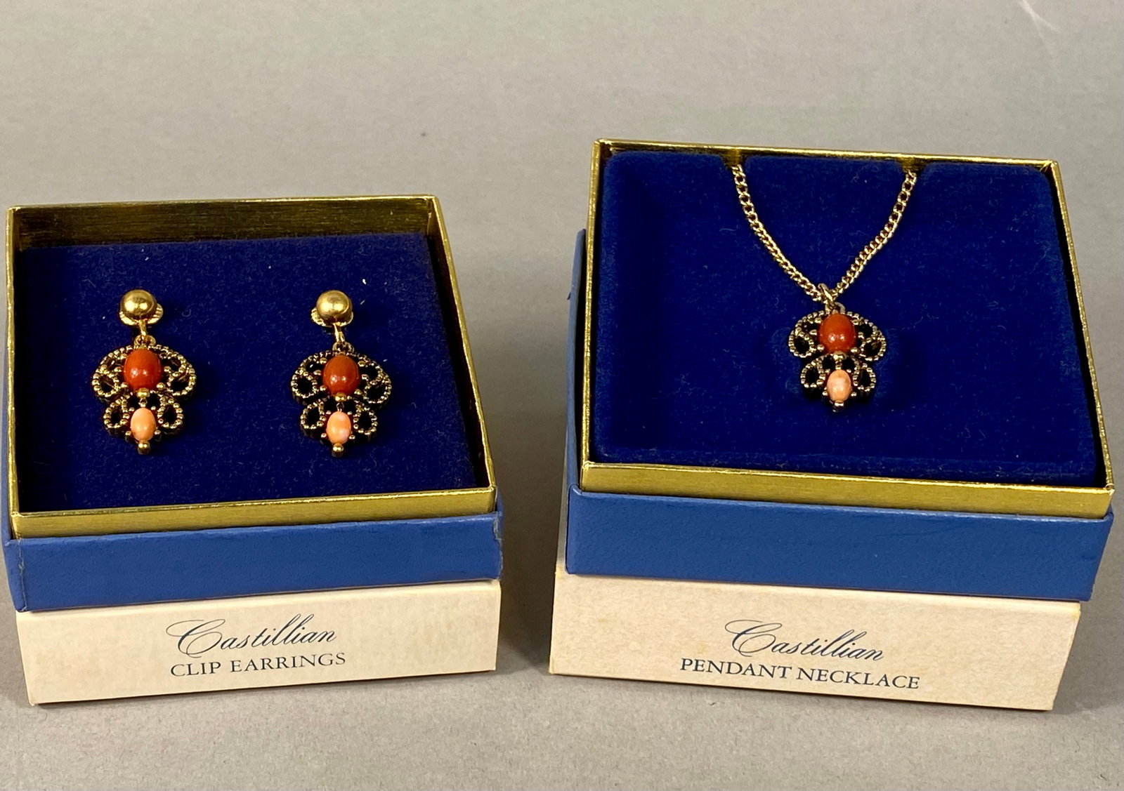 Avon 1974 Castillian Collection Jewelry Set: This vintage jewelry set from the 1974 Avon Castillian collection consists of a matching pendant necklace and a pair of clip-on drop earrings. Each piece is constructed from yellow gold-tone base meta
