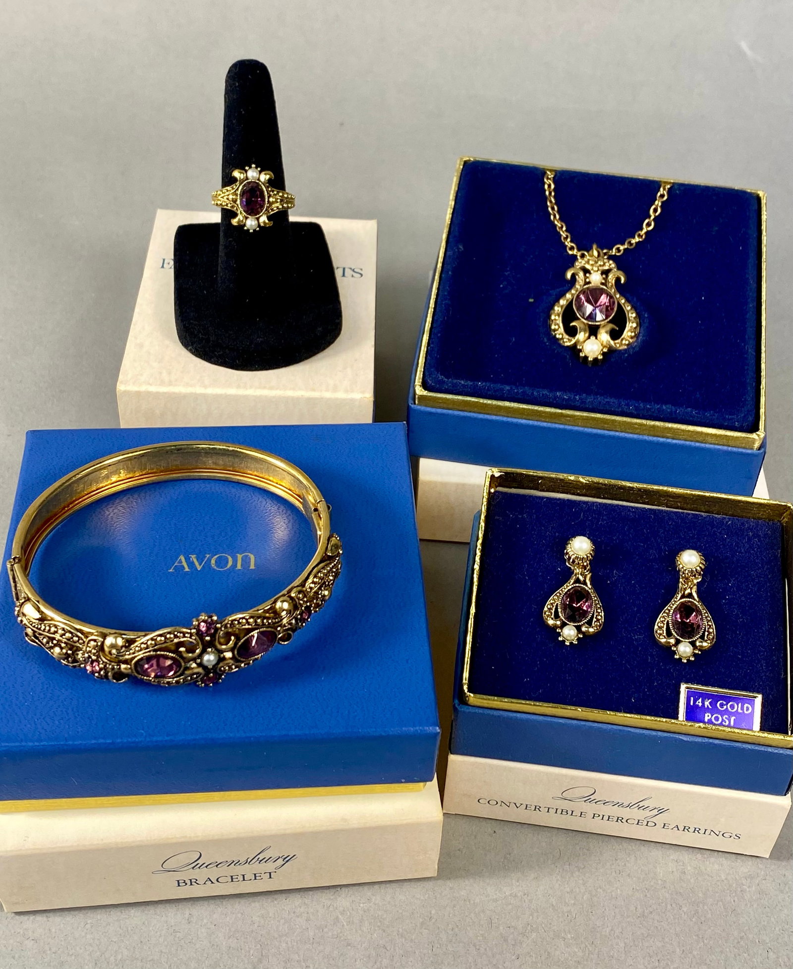 Vintage 1974 Avon Queensbury Victorian Revival Jewelry Set: A complete set of vintage costume jewelry from the Queensbury collection by Avon, dated 1974. The suite is designed in a Victorian Revival style and includes a hinged bangle bracelet, a pendant neckla